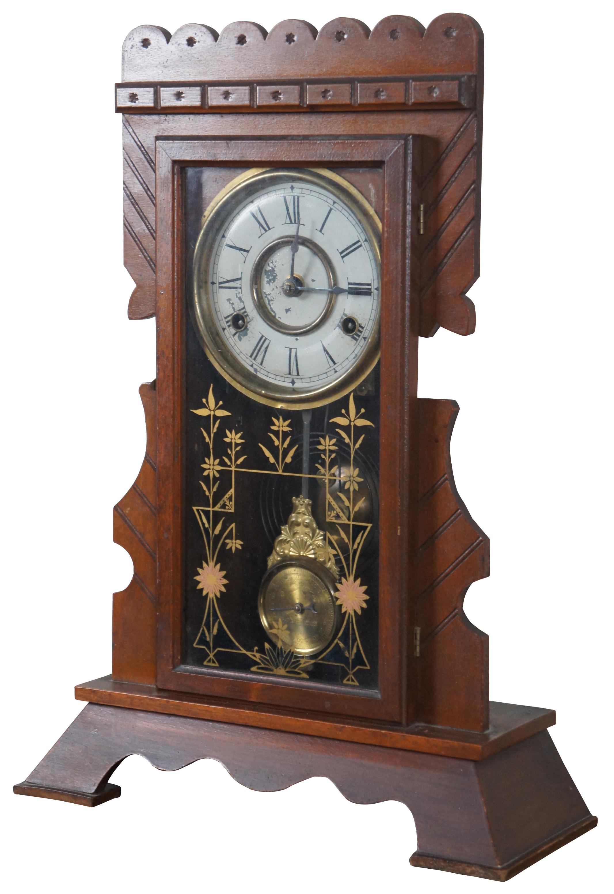 Antique New Haven Clock Company 8 day striking mantel clock model number 511 with carved walnut frame, brass pendulum, painted face and floral painted glass front, Circa 1880s.
 