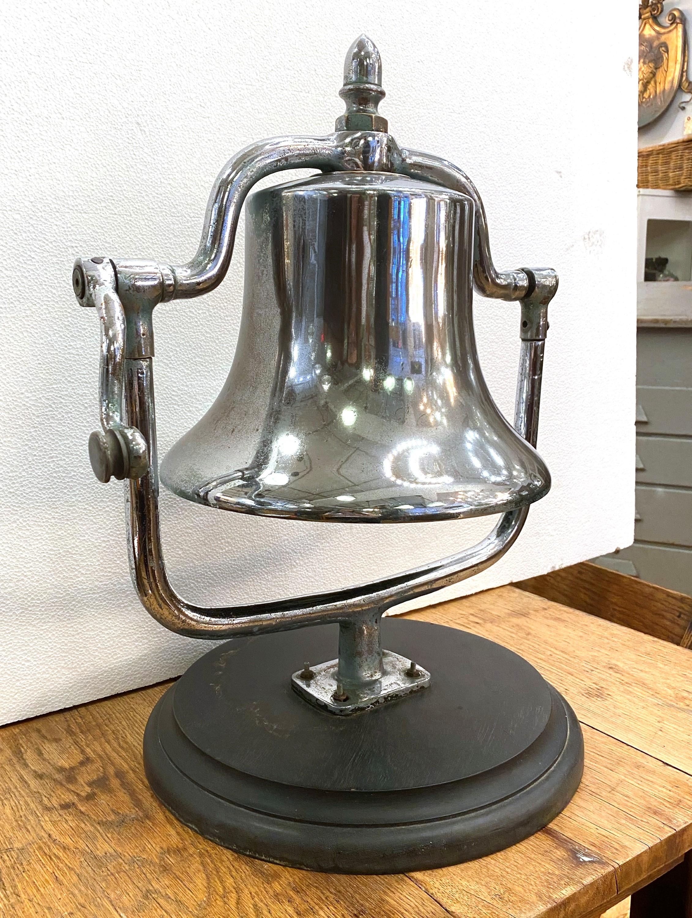 This antique bronze tabletop fire engine bell with a wood base is a rare find. Its nickel-plated bronze construction exudes vintage charm, making it a striking and collectible centerpiece for any fireman's home. It is in very good condition, with a