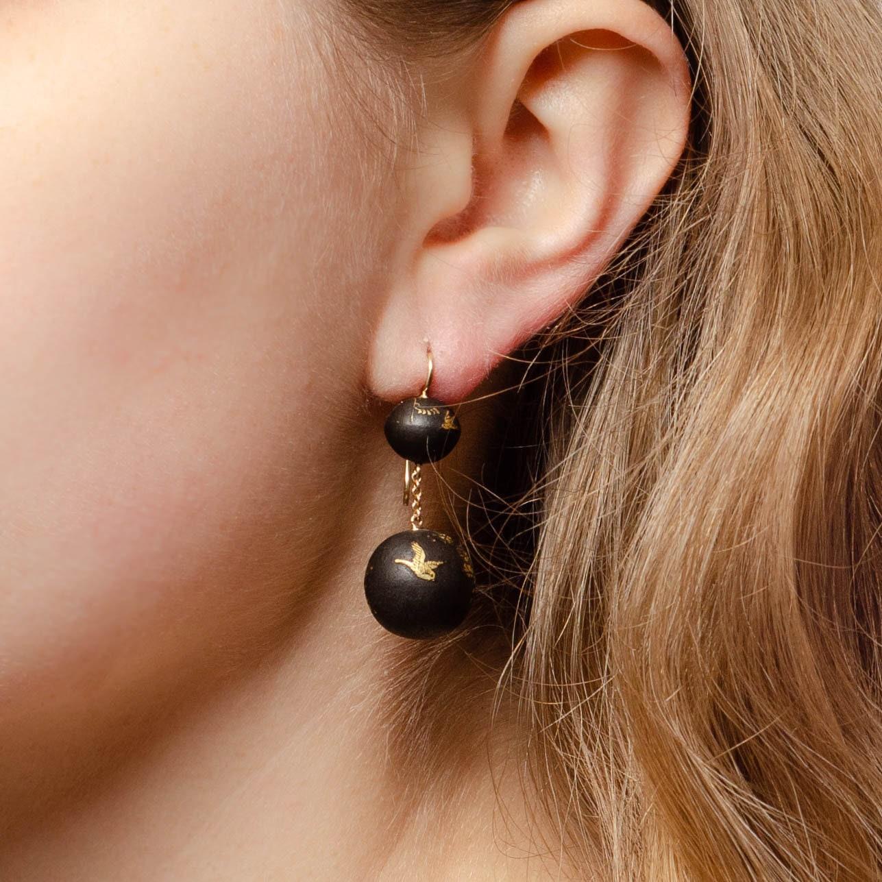 These elegant dangle earrings were converted from antique beads (circa 1880-1900). The earrings are a darkened metal hand etched and accented with gold. The ear wires and chain between the beads are 14k gold.

Each earring measures 1.4 inches from