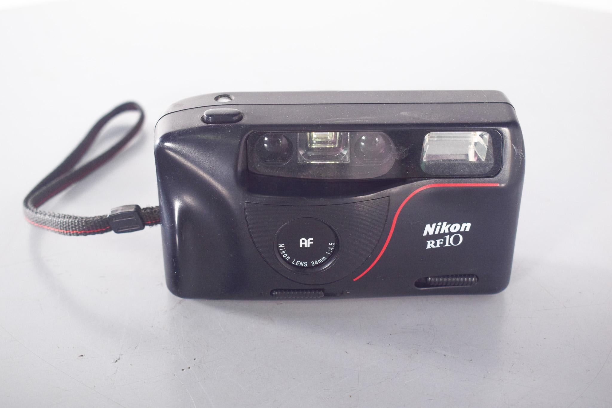 Appareil photo Nikon RF10. Appareil photo compact de 35 mm lancé dans les années 1990, idéal pour la photographie occasionnelle et de voyage. Avec son design ergonomique en plastique noir mat et ses détails rouges discrets, ce point-and-shoot allie