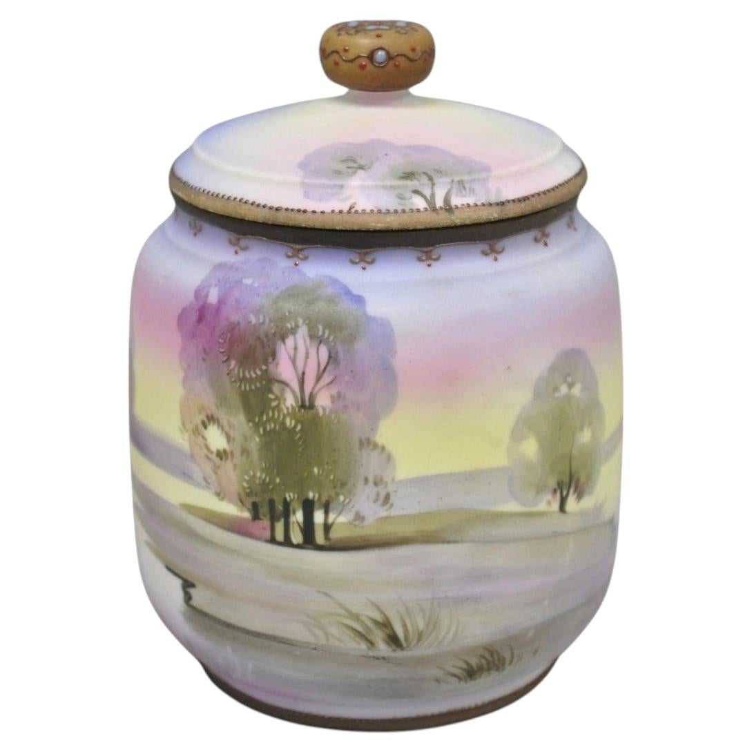 Antiguo tarro de galletas de porcelana pintado a mano de Nippon con una escena lacustre en el campo