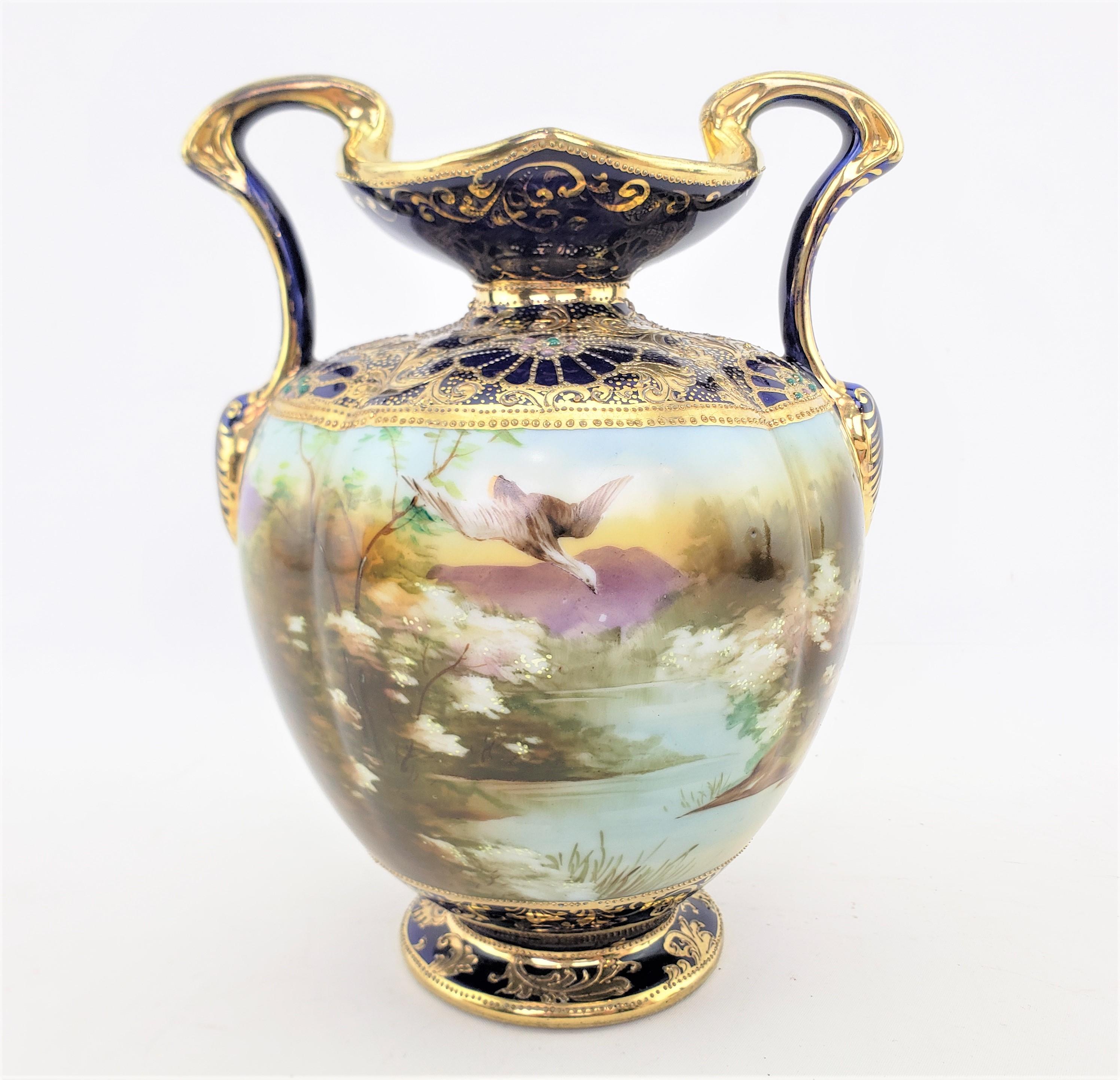 This antique hand-painted vase was made by the well known Nippon Company of Japan in approximately 1920 and done in the period Art Deco style. The vase is composed of porcelain with a cobalt blue ground and heav gilt and moriage or beaded decoration