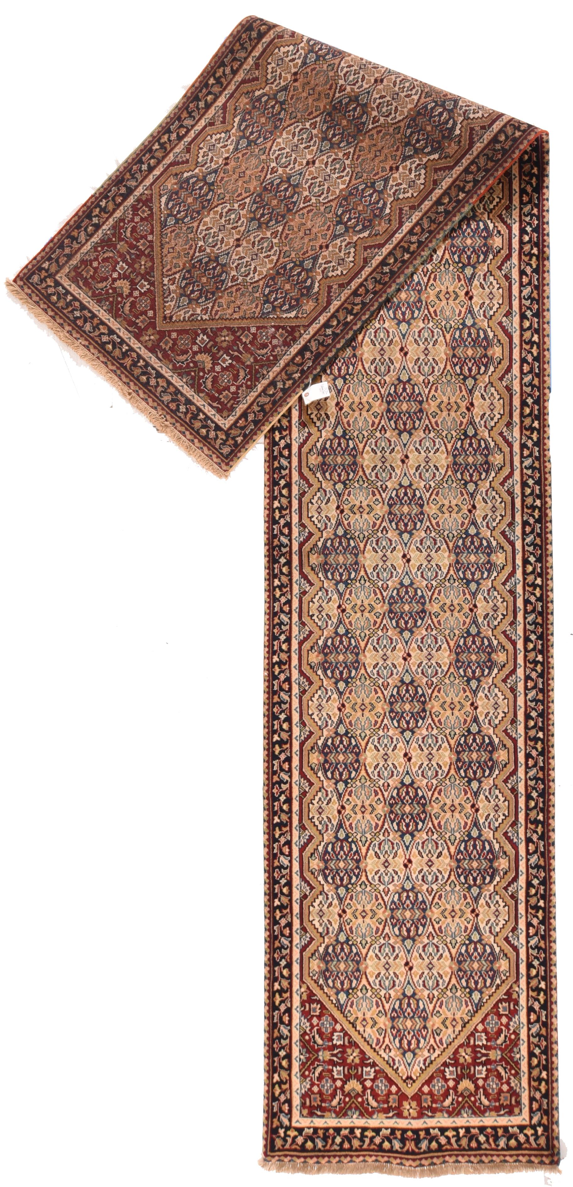 This moderately coarse rustic kenare (runner) shows a kilim-style rendition of an ogival trellis in blue-black straw and ecru. In each reserve is a reflected abstract flower motif. Navy-black corners with leaf and rosette Herati pattern. Navy-black