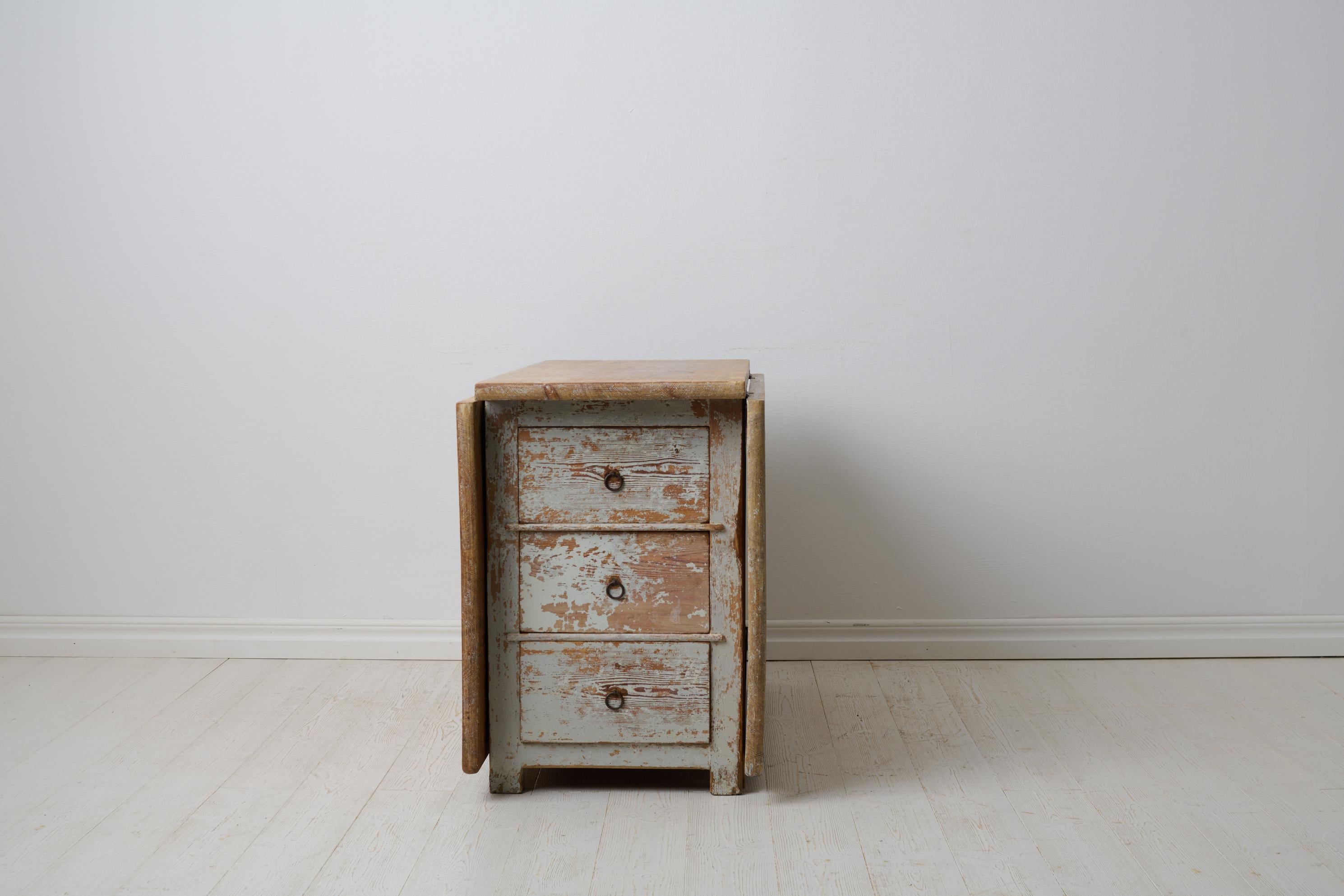 Antiker Klapptisch aus der Zeit um 1840 bis 1860 in Nordschweden. Der Tisch ist ein echtes Landhausmöbel in einer etwas ungewöhnlichen Ausführung mit drei Schubladen auf jeder Seite des Mittelteils. Handgefertigt aus massivem Kiefernholz mit einer