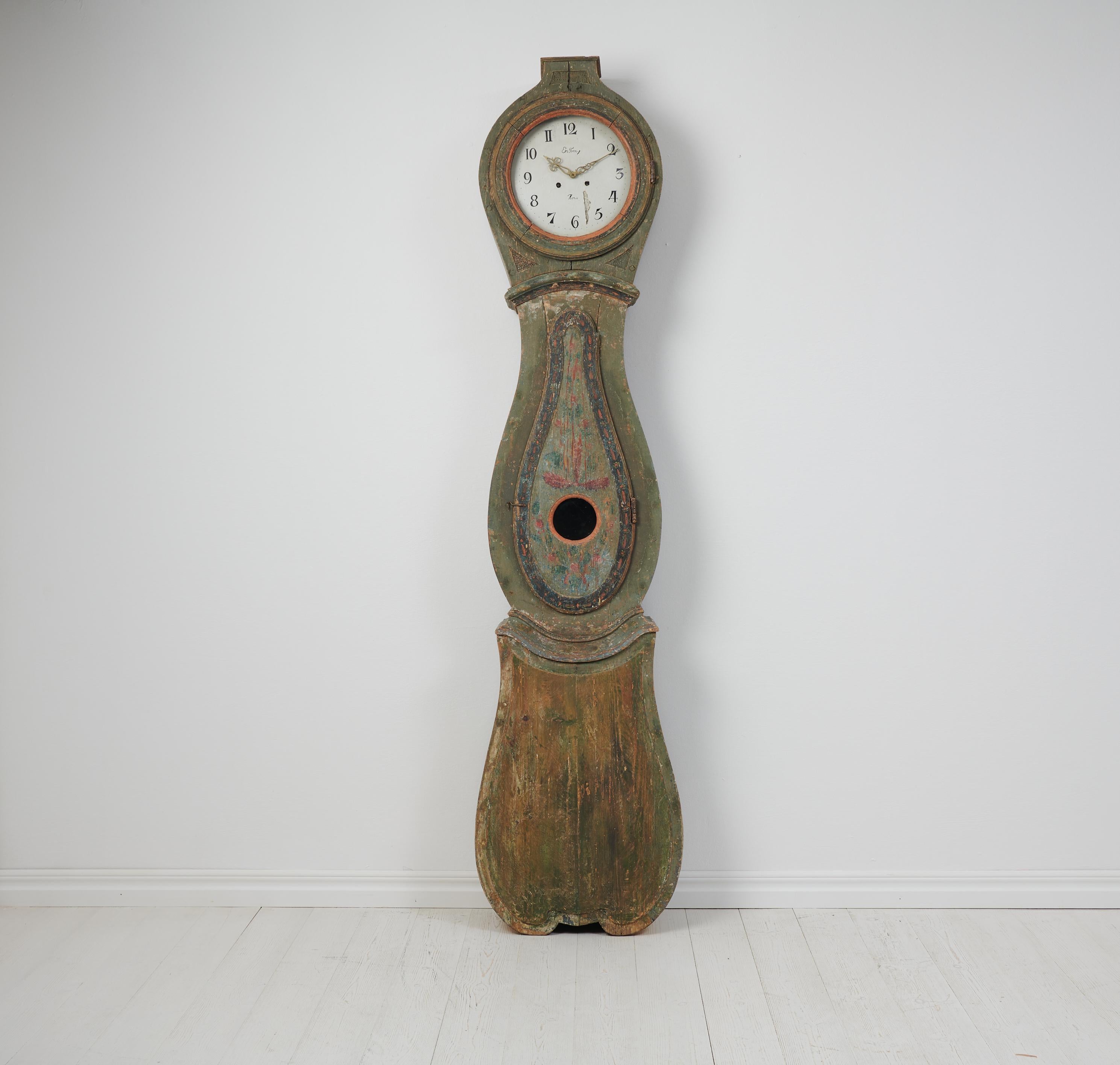 Horloge de campagne à long boîtier fabriquée en Suède au cours du 19e siècle, entre 1820 et 1840. L'horloge est un ancien meuble de campagne du nord de la Suède, fabriqué en pin suédois massif. L'horloge possède un boîtier authentique de forme