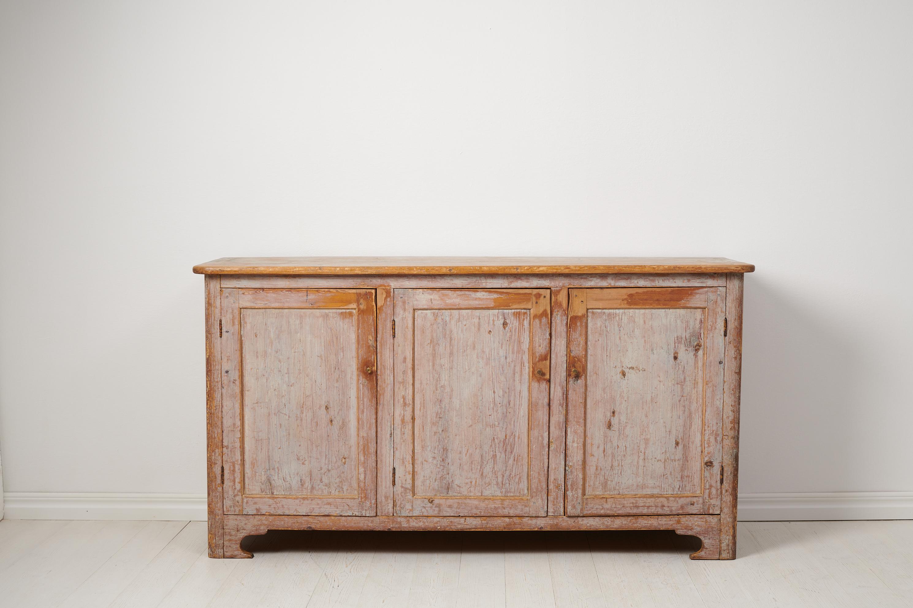 Antique country house sideboard from northern Sweden made around 1840. The sideboard is a genuine Swedish country house furniture made by hand in solid pine. The sideboard has old historic paint with traces of use and distress to the paint.

The
