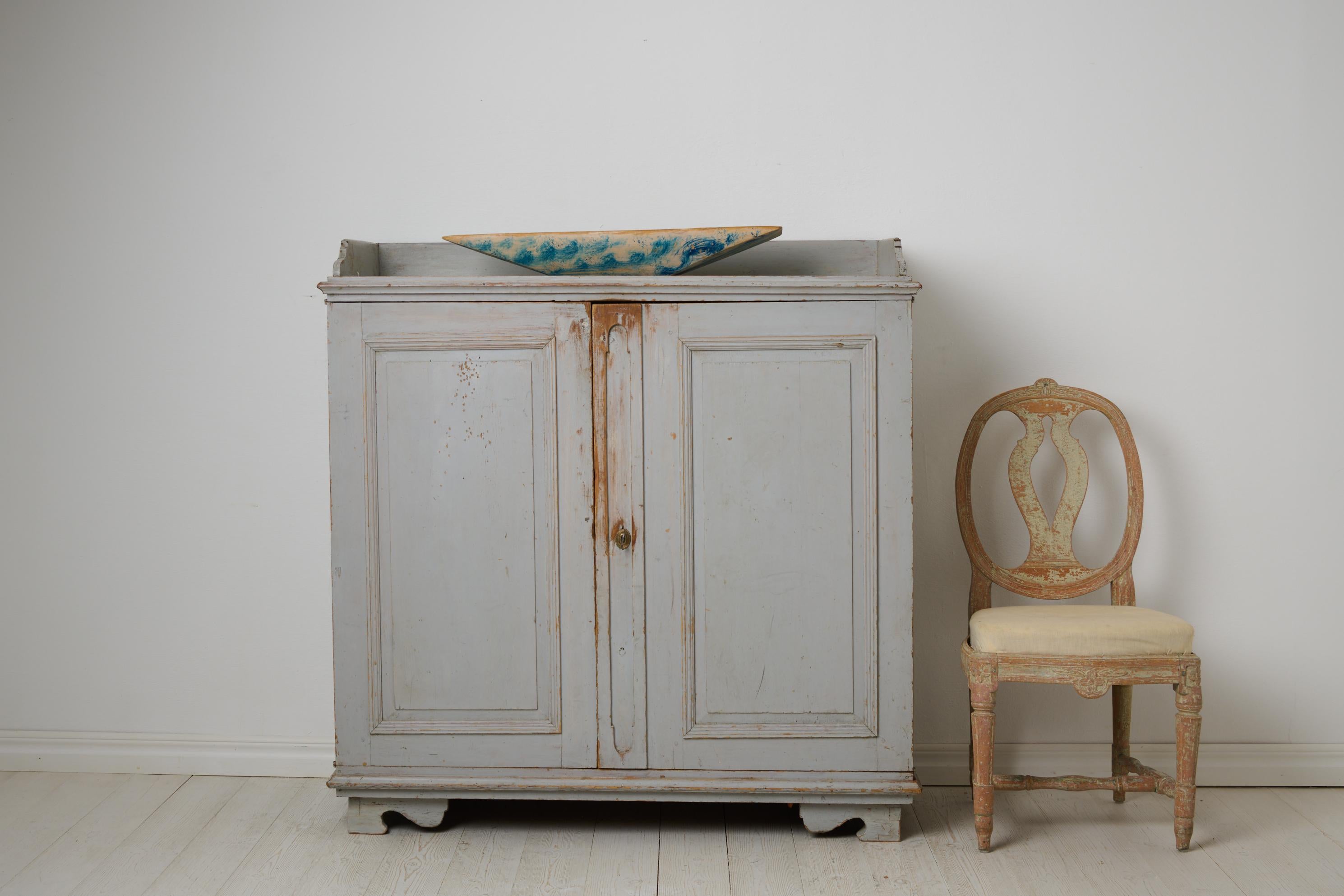 Antique Swedish rustic sideboard from northern Sweden. The sideboard is an authentic country house furniture from around 1840. Classic, straight gustavian shape with double doors. Completely untouched with original paint from the 1840s. The interior