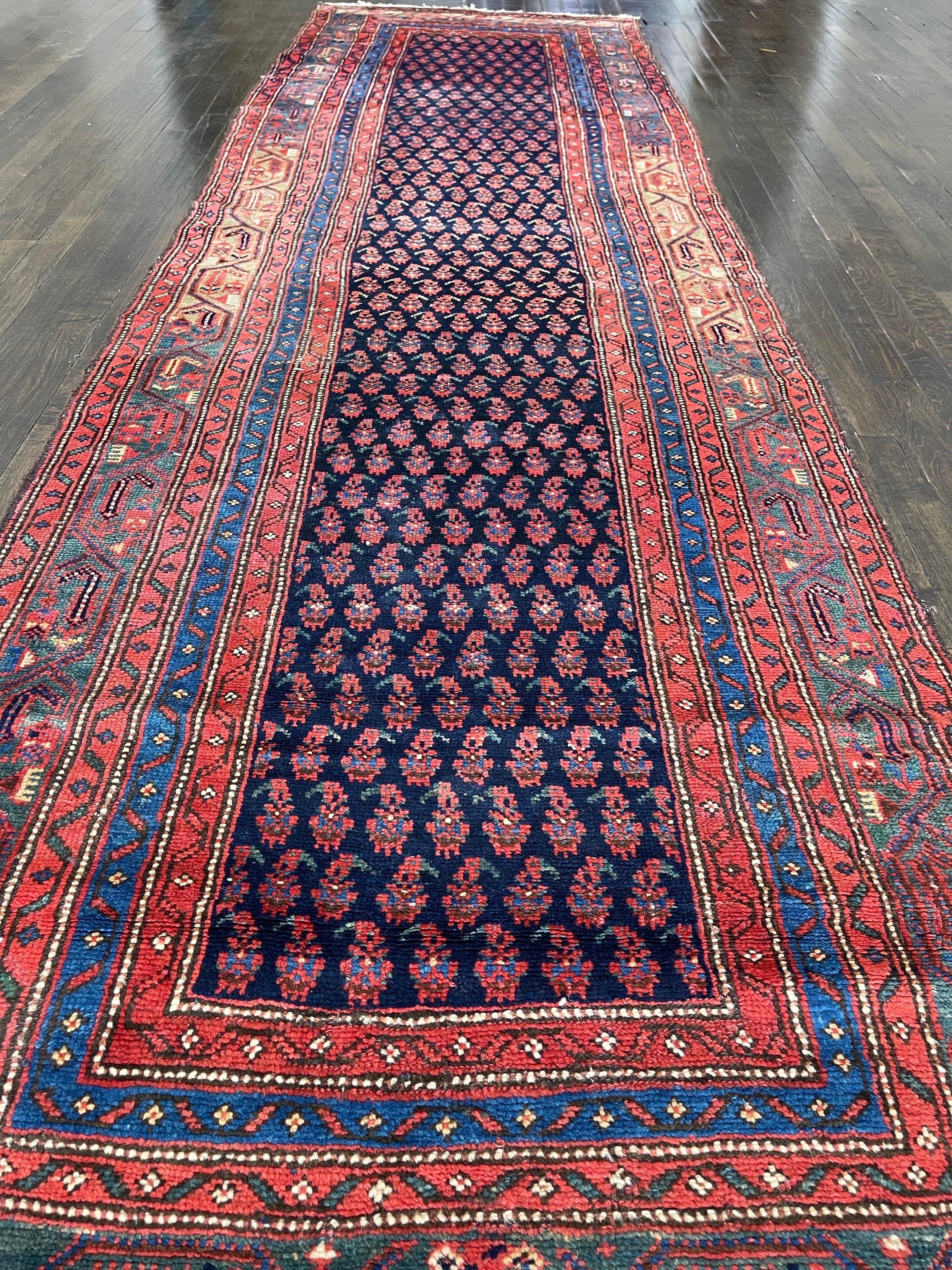 A handsome dark blue runner hand woven in north western Iran.Featuring elegantly curved boteh that are simply drawn; complexities are ruled out by the difficult ikat technique. The pattern comes alive through the contrast of red/maroon with the dark