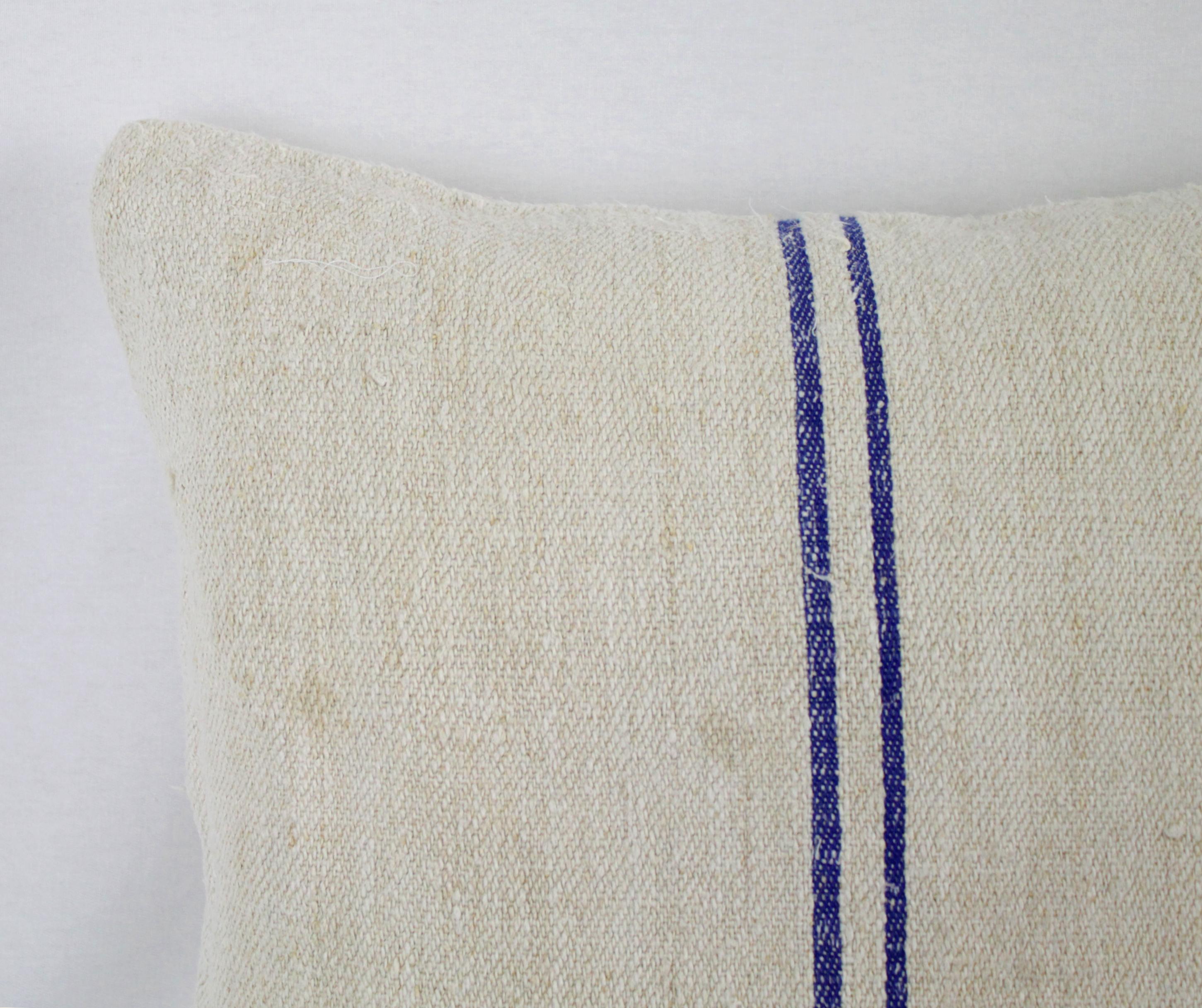 Beautiful pillow made from antique farmers grain sack, circa 1890-1920. These are a light oatmeal color with two blue stripes in the centre. Each pillow is finished with a zipper closure. Front and back are in the same grain sack, and both are