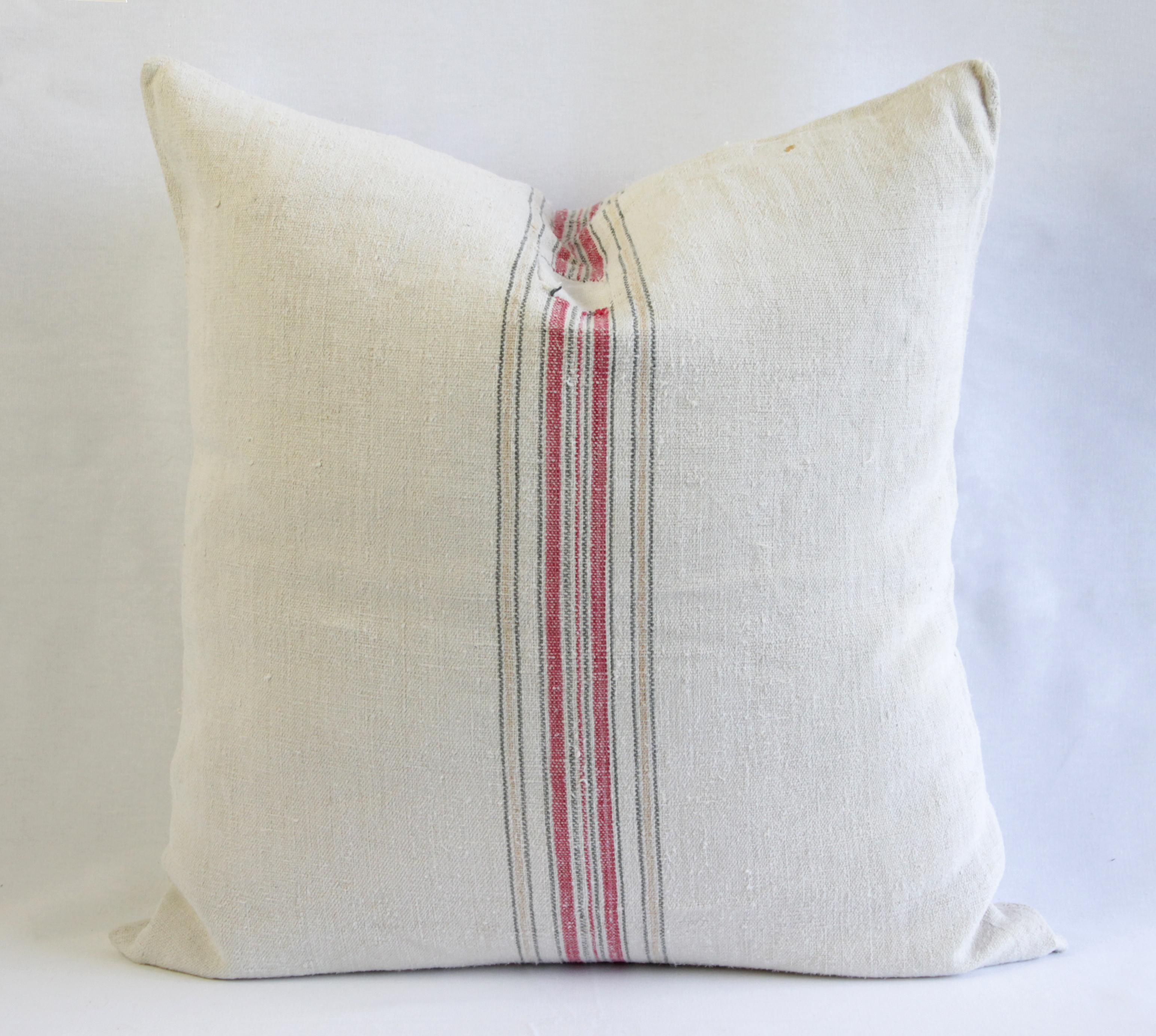 Beautiful pillow made from antique farmers grain sack, circa 1890-1920. These are a light oatmeal color with a red and tan stripes in the centre. Each pillow is finished with a zipper closure. Front and back are in the same grain sack, and both are