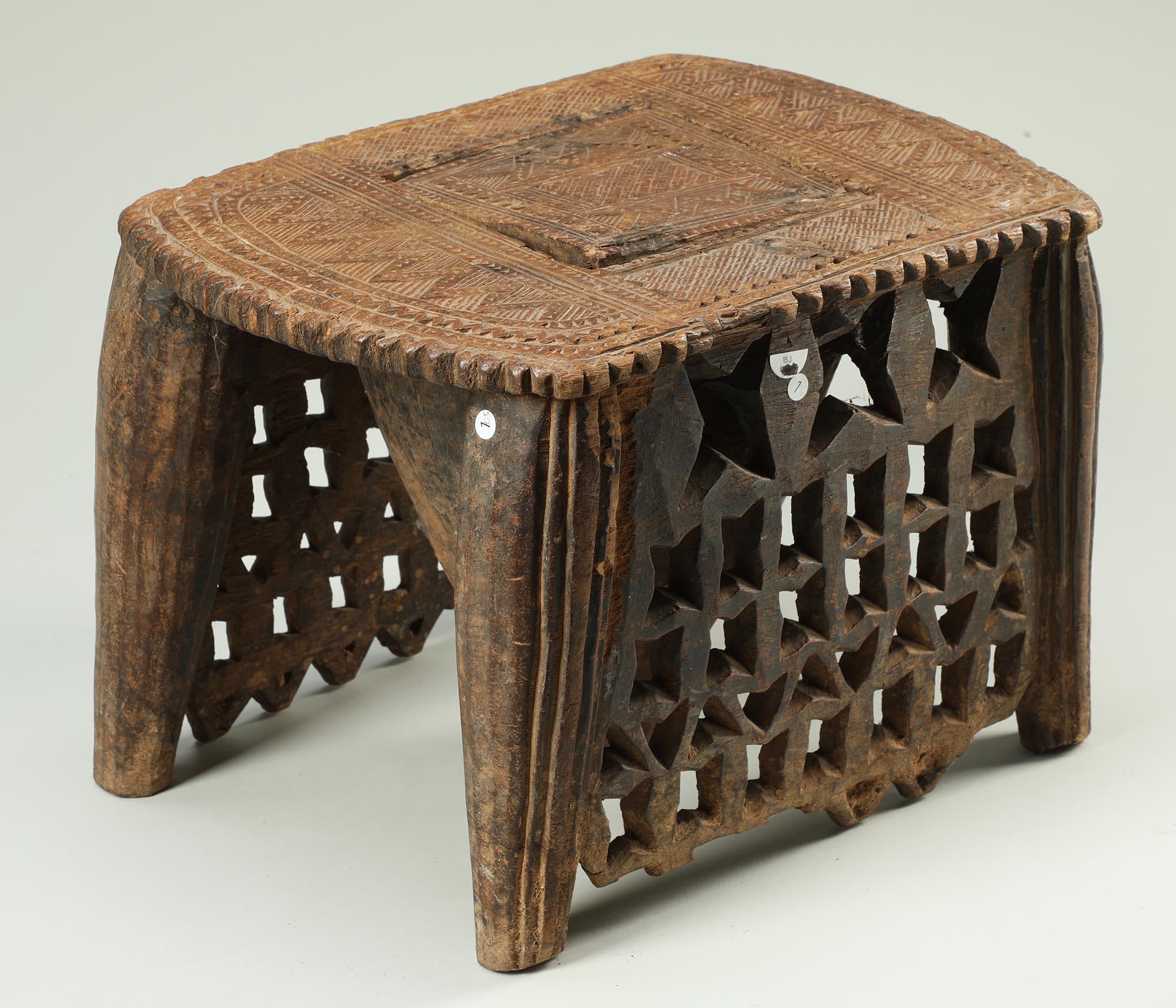 Antiguo taburete Nupe de madera tallada con diseño geométrico calado, Níger África siglo XX en venta