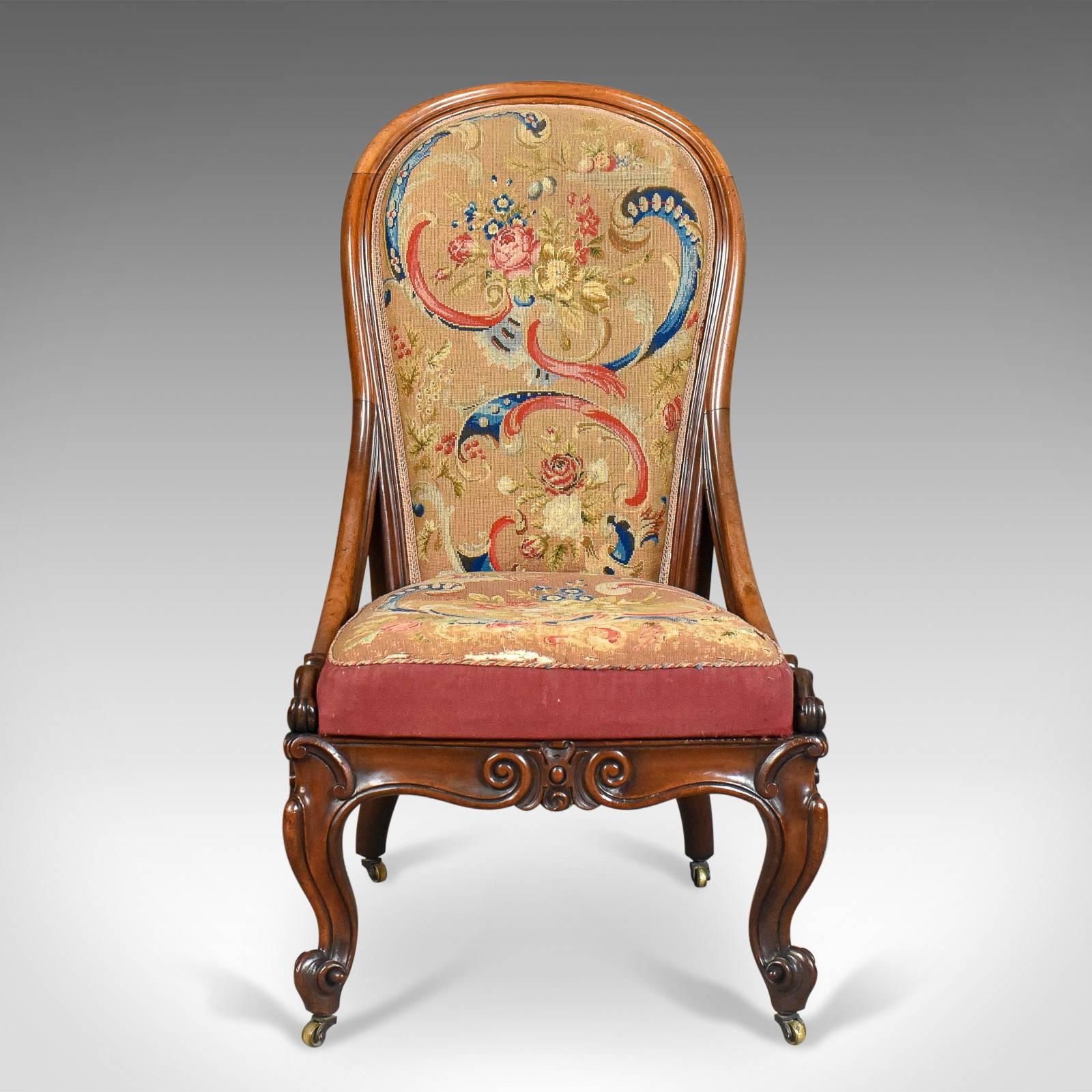 This is an antique nursing chair in English walnut and needlepoint tapestry dating to the early Victorian period, circa 1840.

Superior quality and solid walnut frame displaying good color
Well proportioned with desirable aged