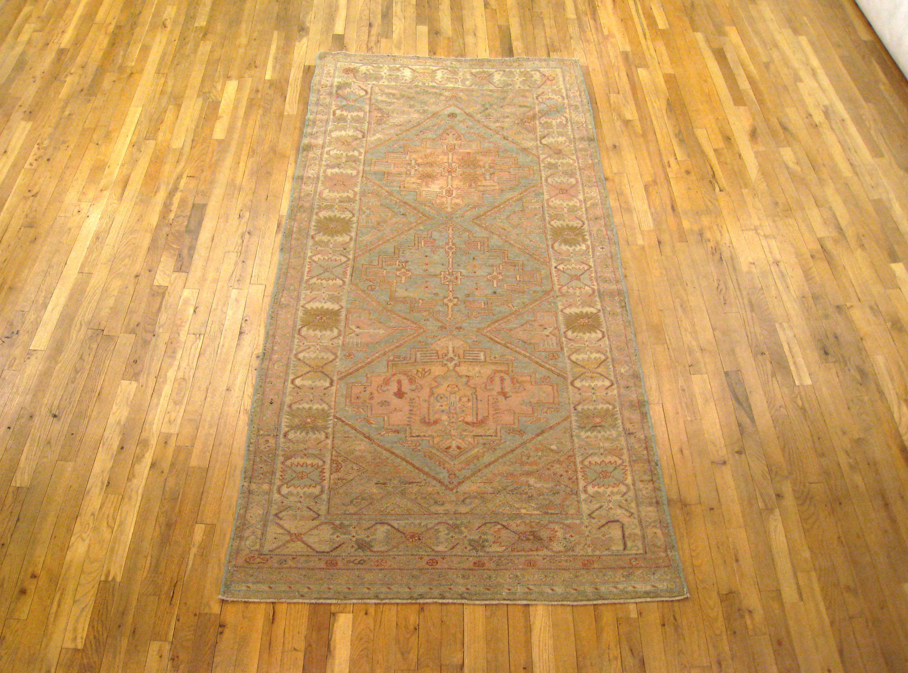 An antique North West Persian decorative oriental carpet, size 8'8 x 4'2, circa 1900. This lovely hand-woven rug features three interconnected diamond shaped cartouches at the center of the softly hued primary field, enclosed within an ivory border