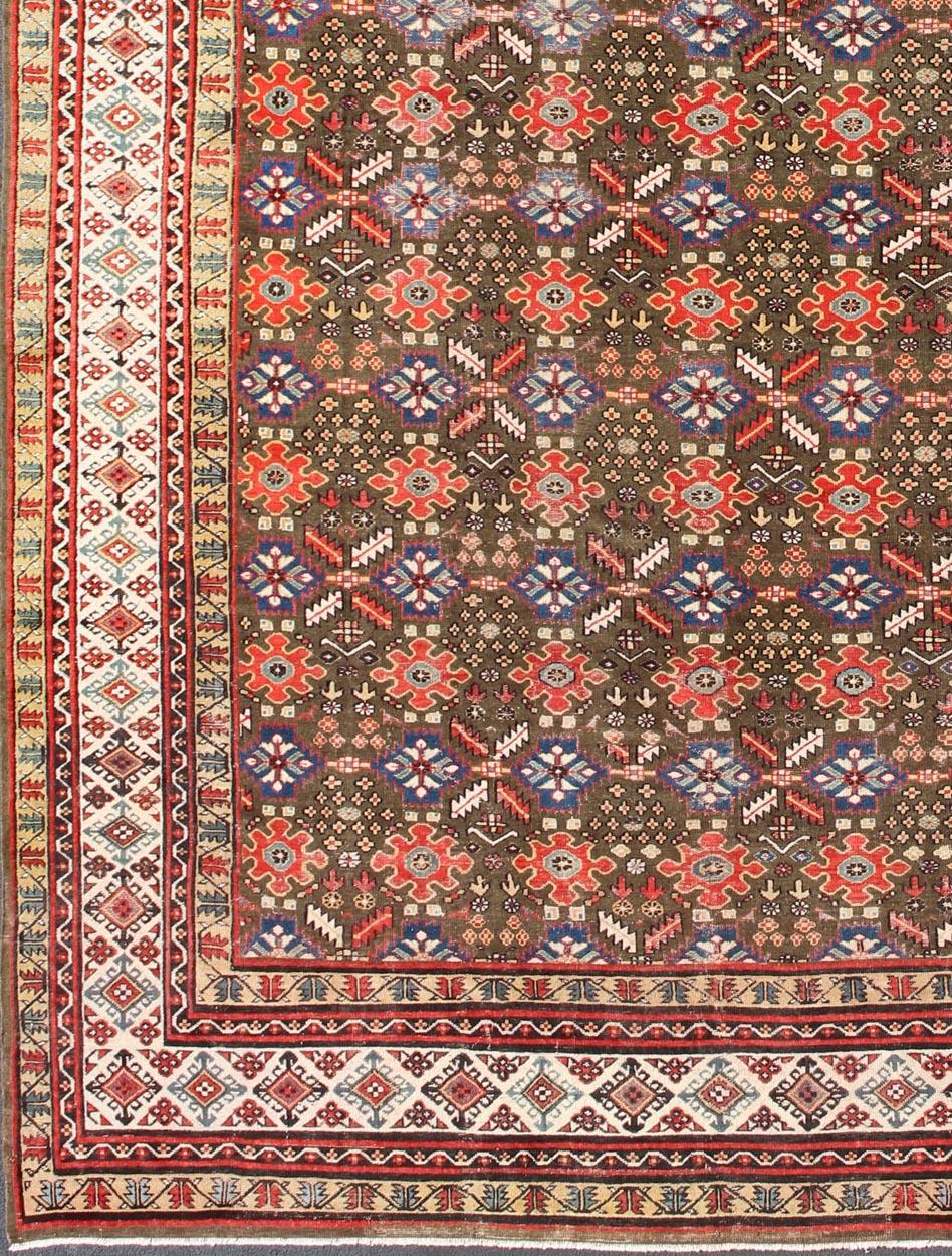 Antique Kurdish rug with brown, red, and blue geometric floral design. Keivan Woven Arts / rug 17-0201, country of origin / type: Iran / Kurdish, Early 19th Century, possible late 18th century.   
Measures: 12'3 x 17'6.   
This 19th century antique