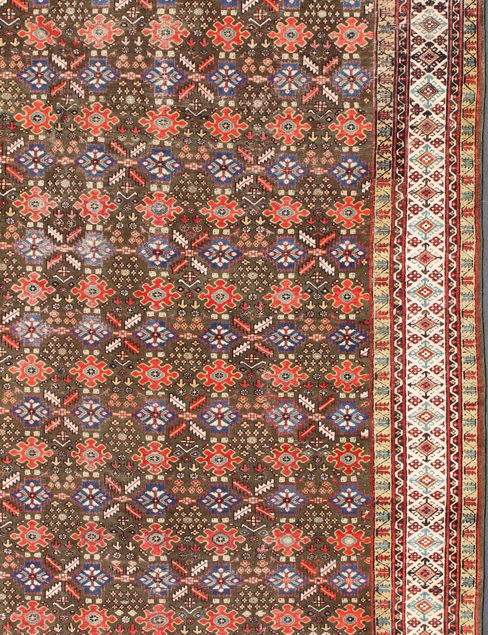 Perse Tapis kurde ancien avec motif sur toute sa surface en brun/vert, rouge et bleu en vente