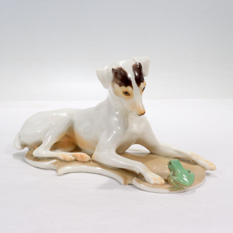 A fine antique Nymphenburg porcelain figurine.

Modeled by Theodor Karner.

In the form of a reclining dog peering inquisitively at the frog between its front paws.

With a decorator's monogram & date on the top of the plinth - L.C.F.