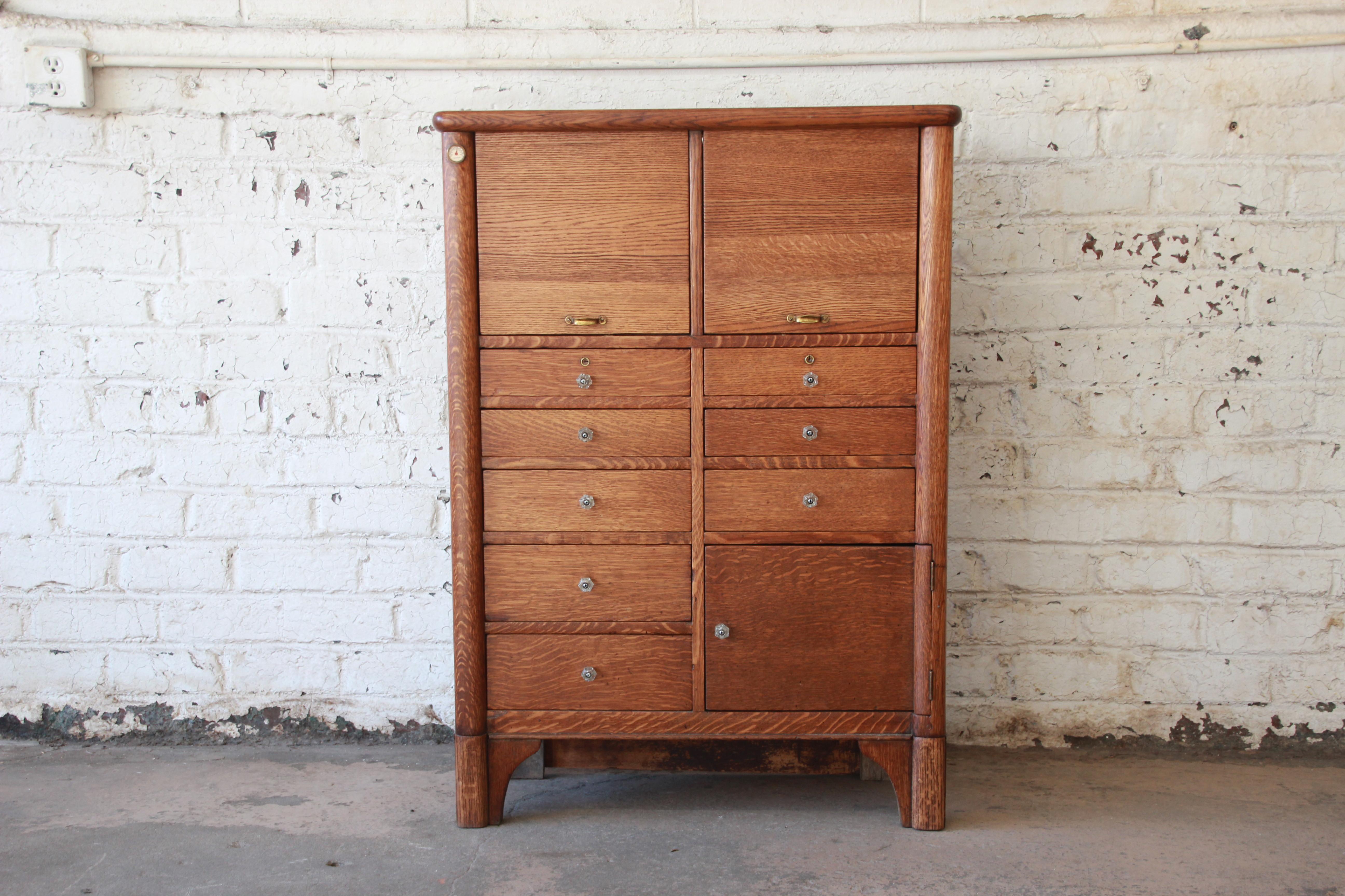 A rare and exceptional antique oak dental or medical cabinet. The cabinet features solid oak construction and all original hardware. It offers ample room for storage, with 22 drawers as well as a cabinet space behind one door. It also has a built-in