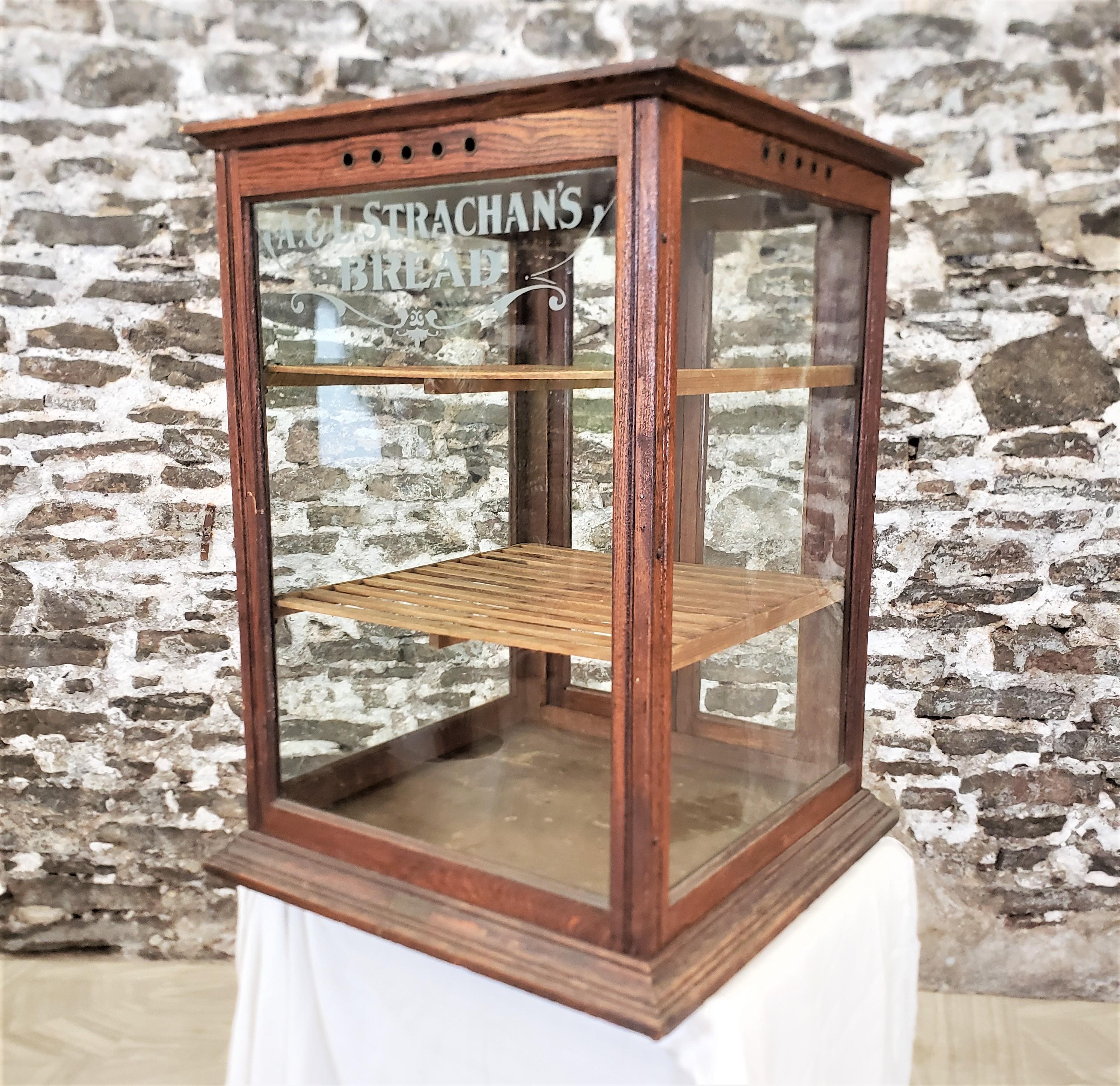 This antique store display cabinet was made by the Schwambeck Brothers of Detroit Michigan in approximately 1897 in the period Victorian style. The cabinet is composed of oak with slatted shelves made of pine. The cabinet has glass on all four sides