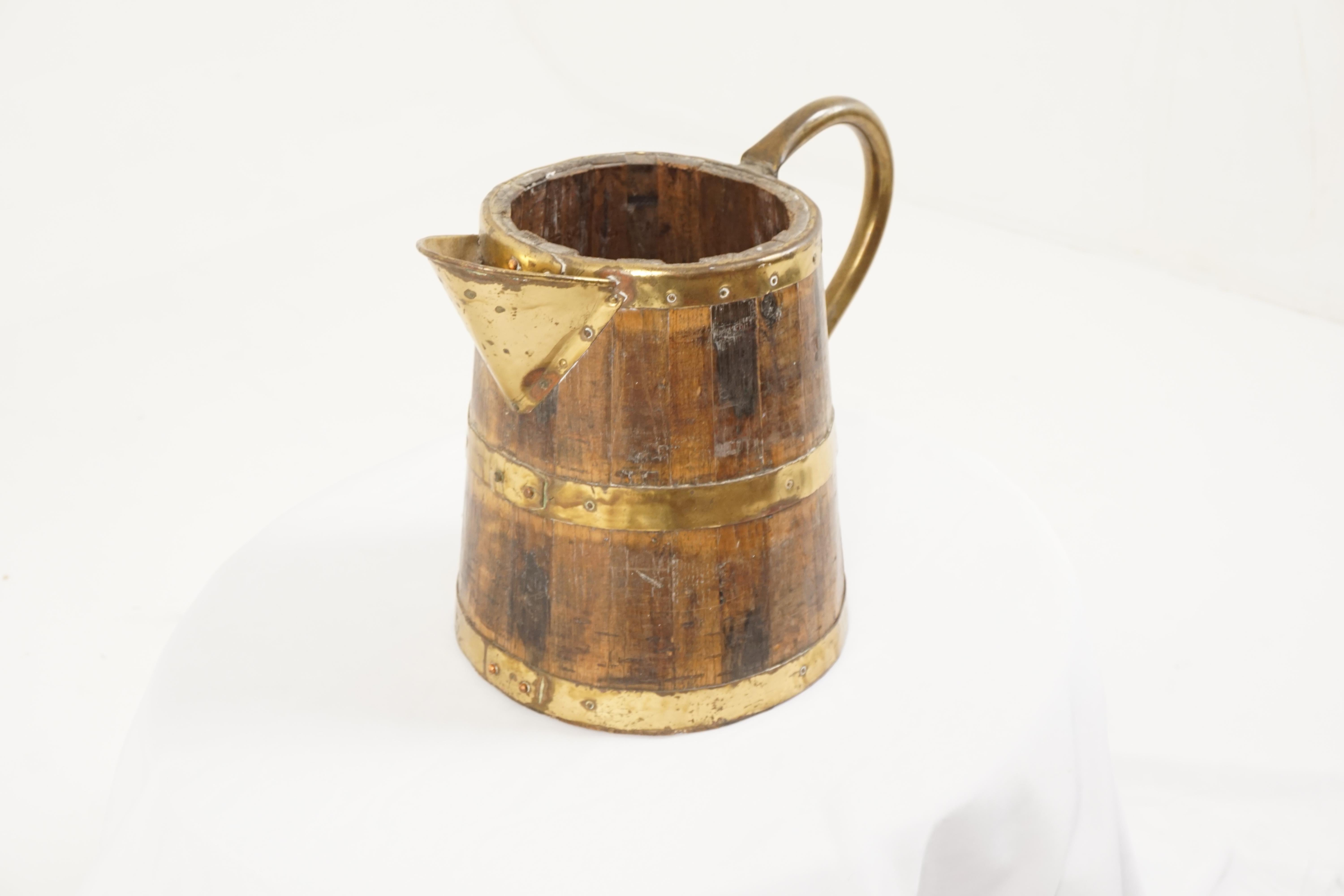 Antique oak and brass bound jug, Scotland 1910

Scotland 1910
Solid oak and brass
Coppered construction
Shaped handle on one end large brass spout on the front
Three brass bands
Nice decorative piece for the bar or in your