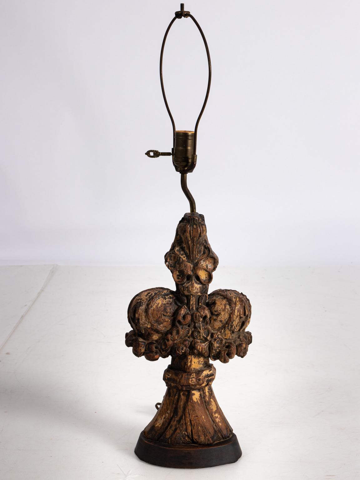 Carved architectural fragment repurposed as a lamp, circa 18th century. The piece also shows traces of paint possibly from a church. Please note of wear consistent with age including old patina along with cracks and traces of old gesso and paint.