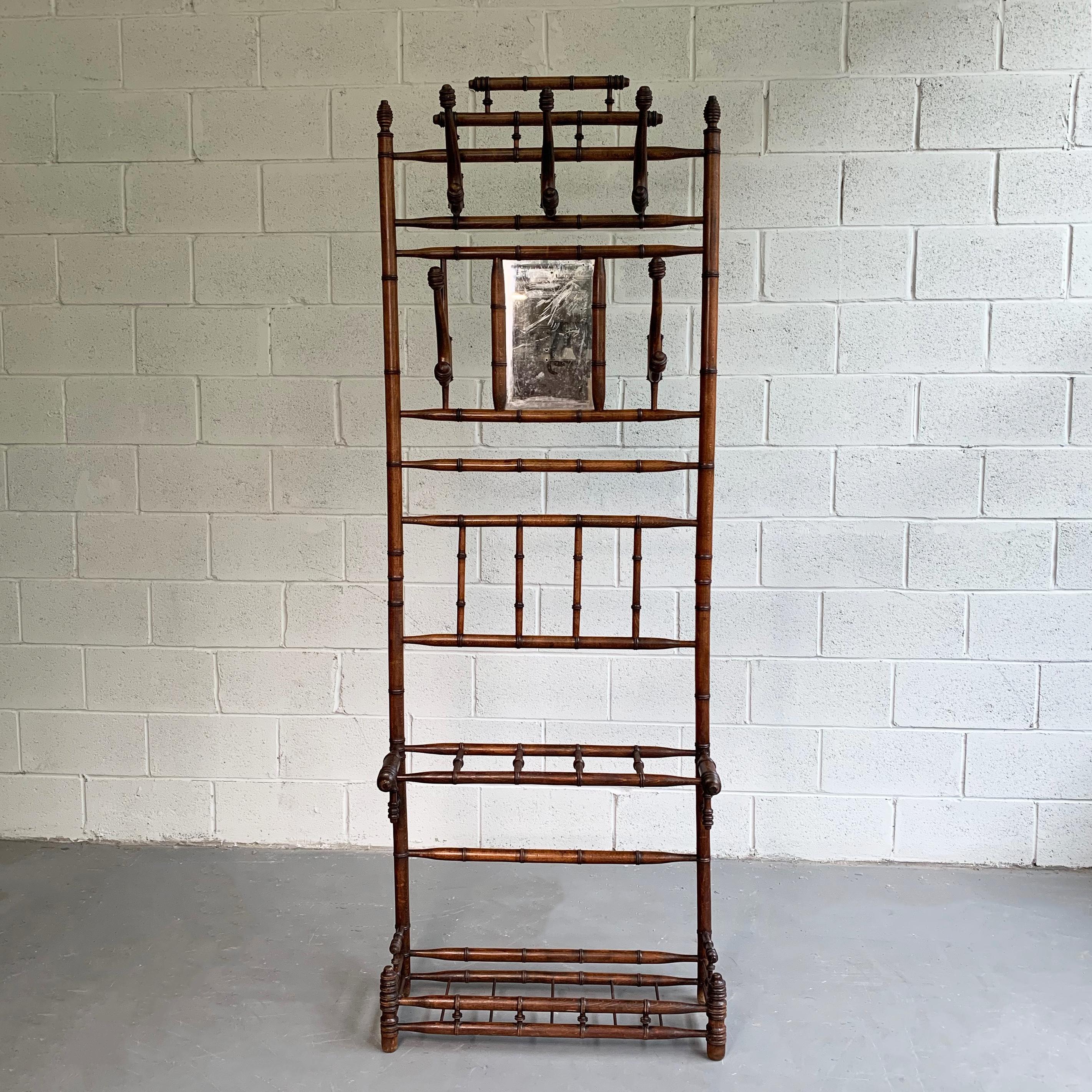 Antique, entryway, hall tree, coat rack features a turned, quarter sawn oak, bamboo motif frame with 5, double, articulating, steam-bentwood hooks, vanity mirror at 53 inches height and slots for umbrellas at 23 inches height.