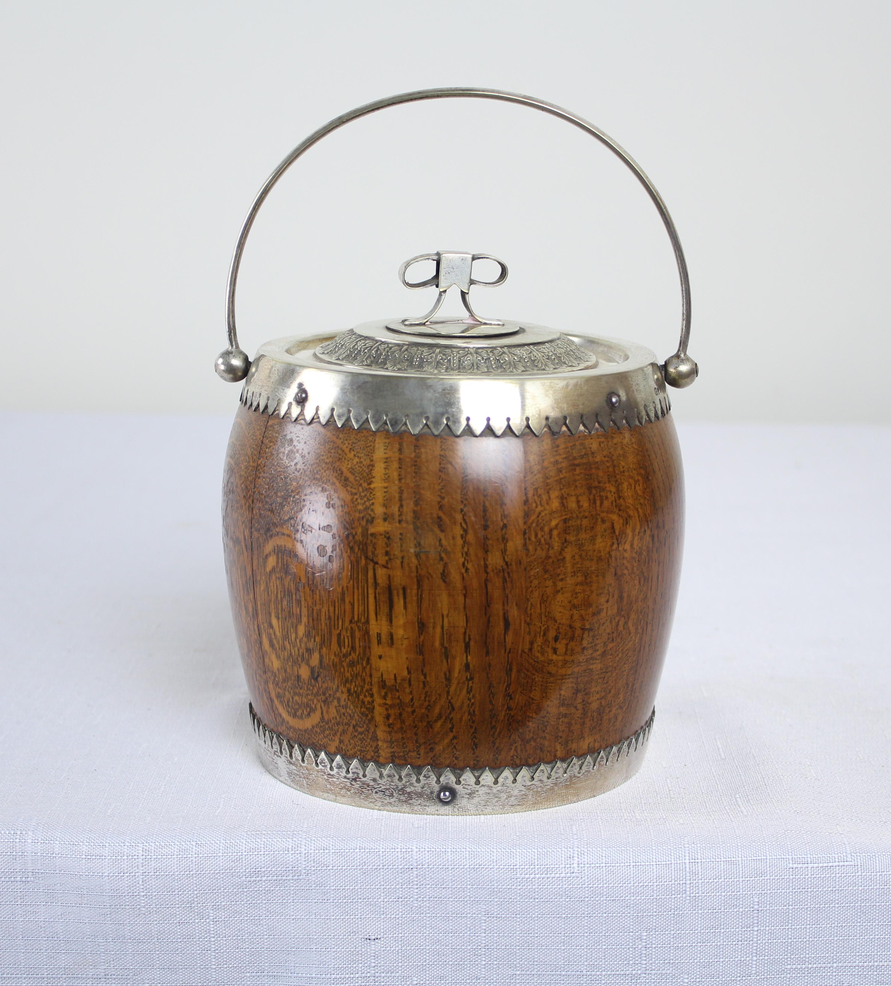 A charming oak biscuit barrel from the late 19th century. The metal is stamped “EPNS”, or Elecro Plated Nickel Silver, a metal alloy that is then silver plated. Traditional porcelain liner and sweet handle. The top has a great molded bow.