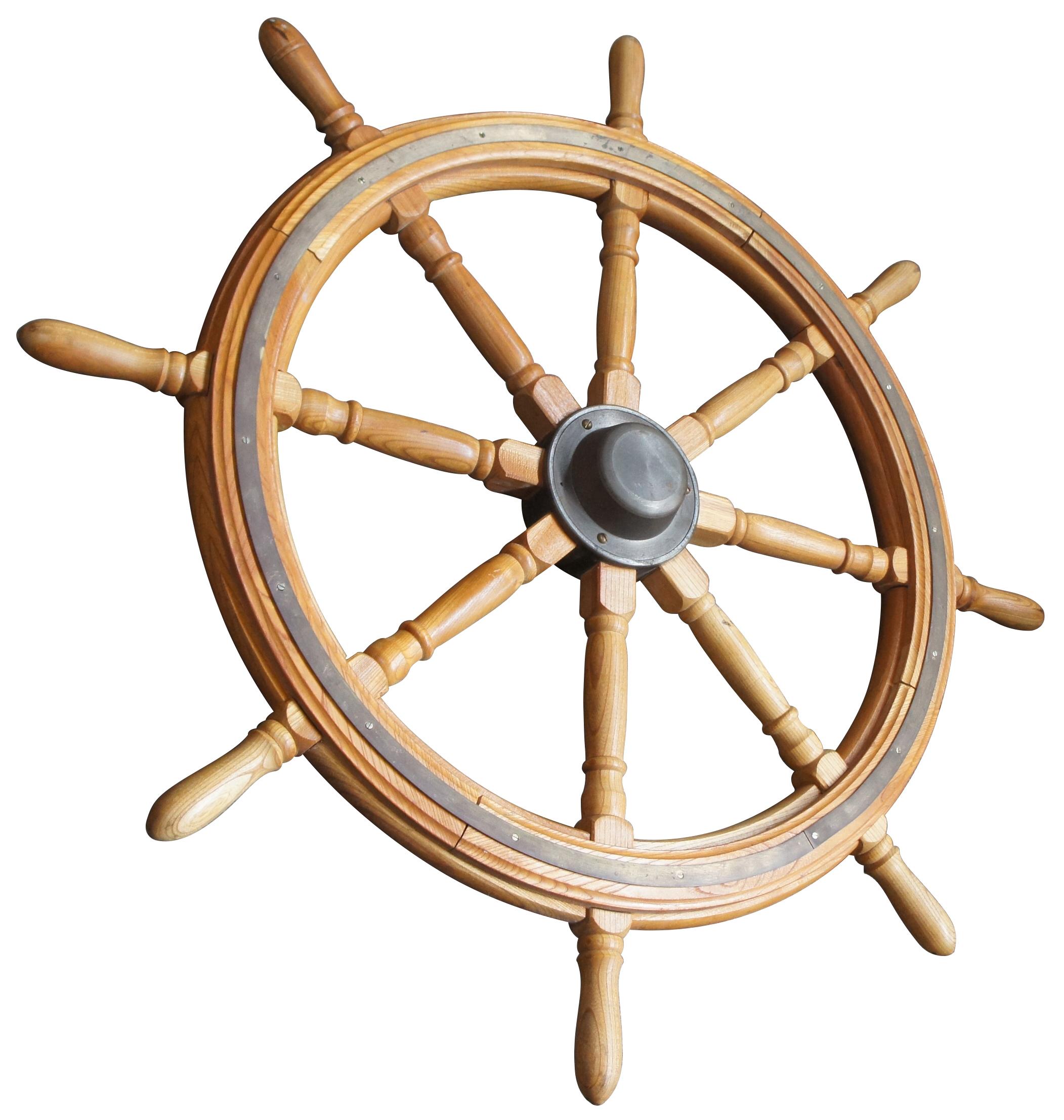 Antique oak and brass boat or ship wheel featuring rounded form with turned posts. Measure: 41
