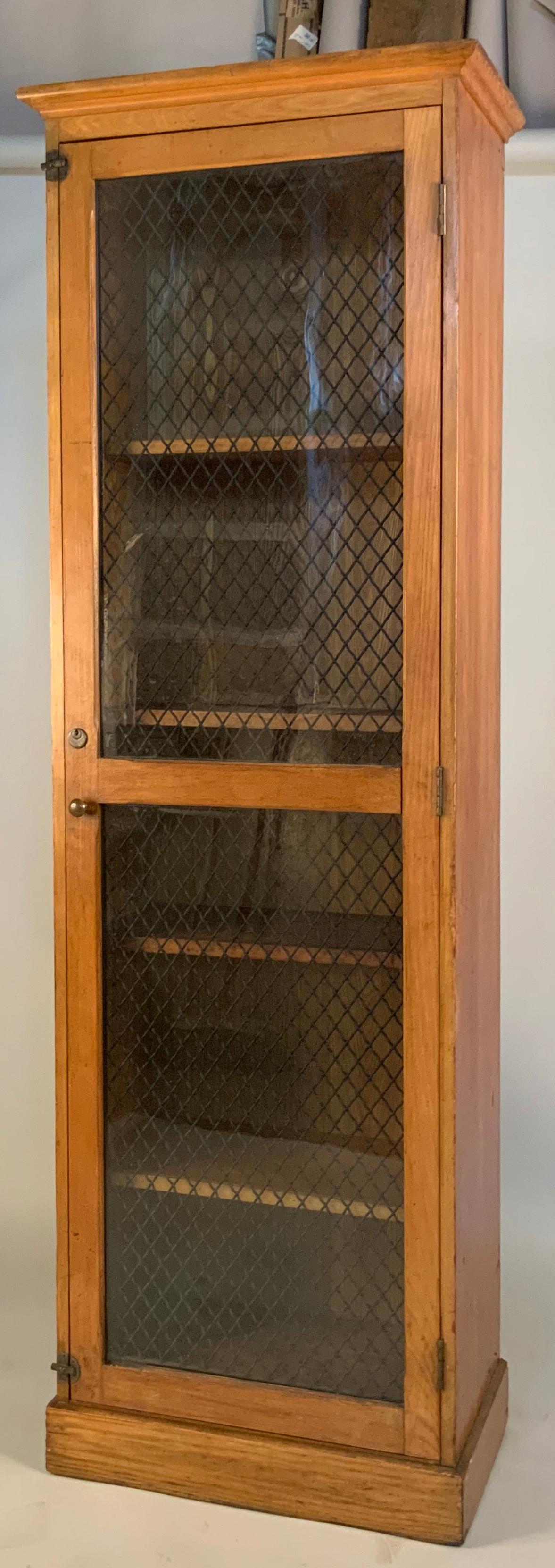 A beautiful antique oak cabinet with a door with original antique glass, and wavy wire cage behind it. Interior has adjustable shelves. The door has brass latches top and bottom, and a lock in the center. Good condition with age expected wear