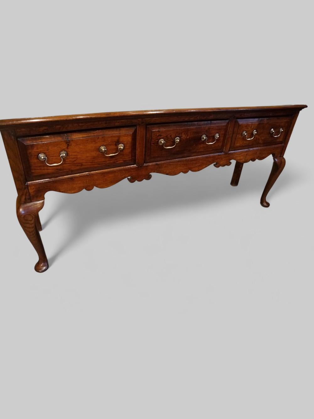 Antique oak cabriole leg dresser
This Antique oak cabriole leg dresser was made circa 1900.
It is fitted 3 drawers all with brass swing swan neck handles, the drawer fronts with the bevelled edges.
Under the drawers is the very attractive shaped
