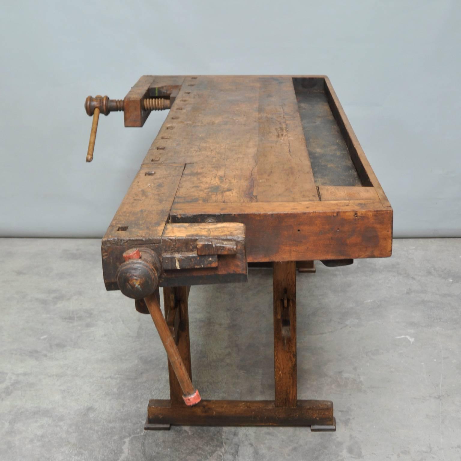 This vintage Hungarian carpenter’s workbench features two vices and a recessed tray where the carpenter would lay his tools. It was manufactured, circa 1930. It has been restored and waxed, so it's ready for use. Please examine the close up photos