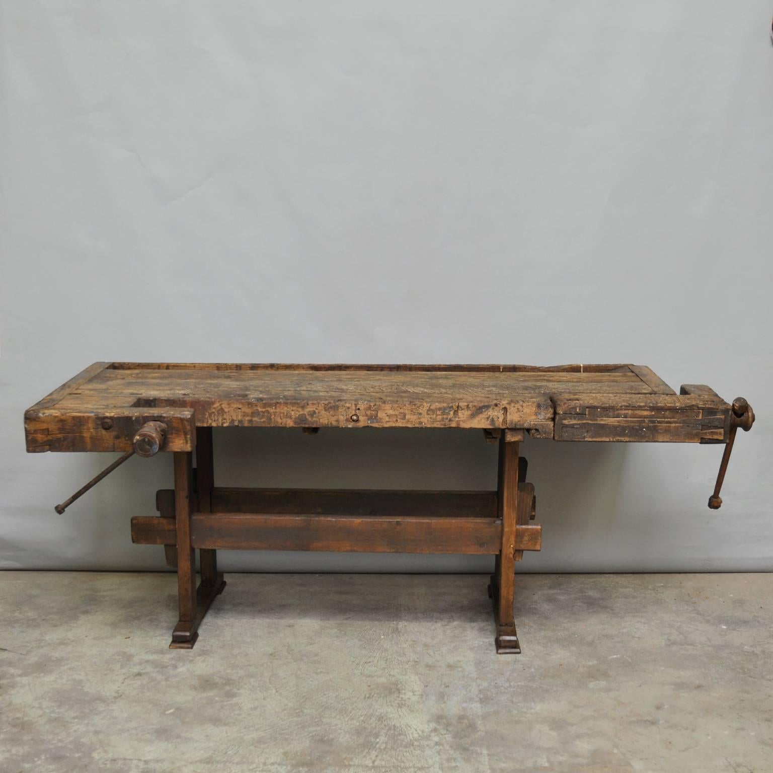 This vintage Hungarian carpenter’s workbench features two vices and a recessed tray where the carpenter would lay his tools. It was manufactured circa 1935.