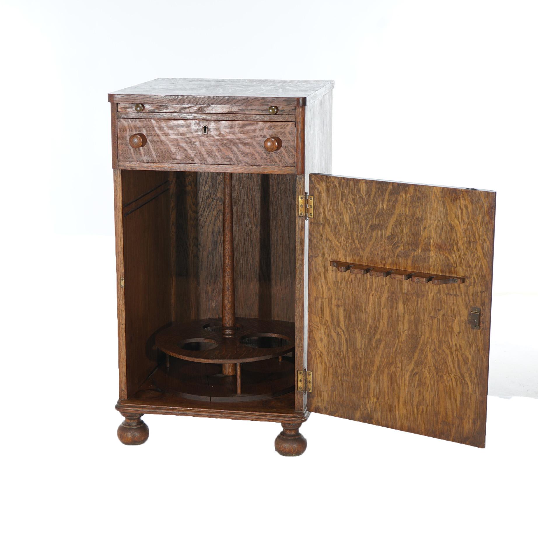 An antique cellarette offers quarter sawn oak construction with pullout mixing tray over single drawer and door opening to lazy Suzanne bottle 
 shelf, c1910

Measures- 34''H x 18.5''W x 19''D