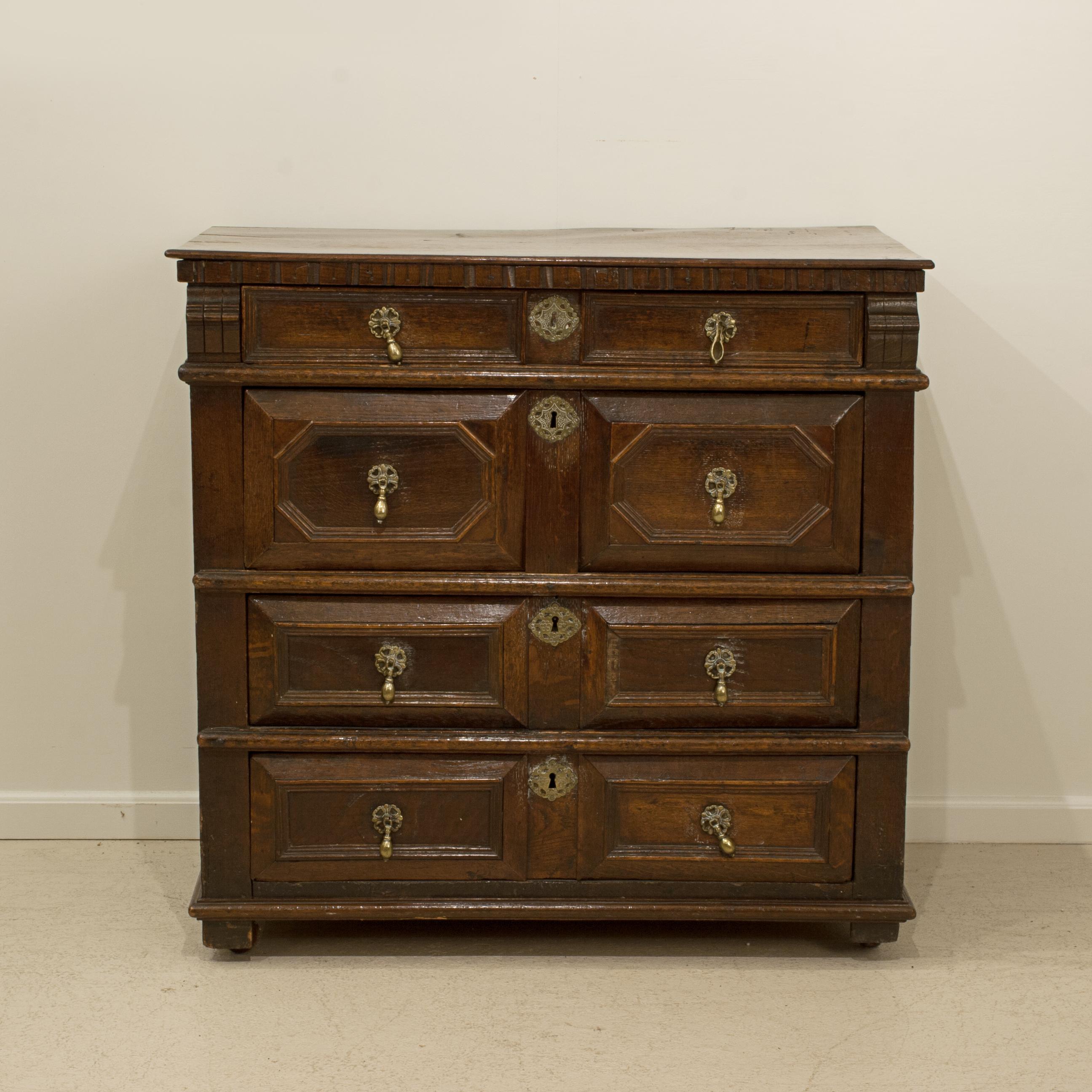Commode de style jacobéen.
Une belle commode ancienne en chêne de style jacobéen, bien proportionnée, montée sur quatre roulettes. Les tiroirs à moulures en forme de coussins sont de pleine longueur et sont dotés de poignées de tirage en laiton avec