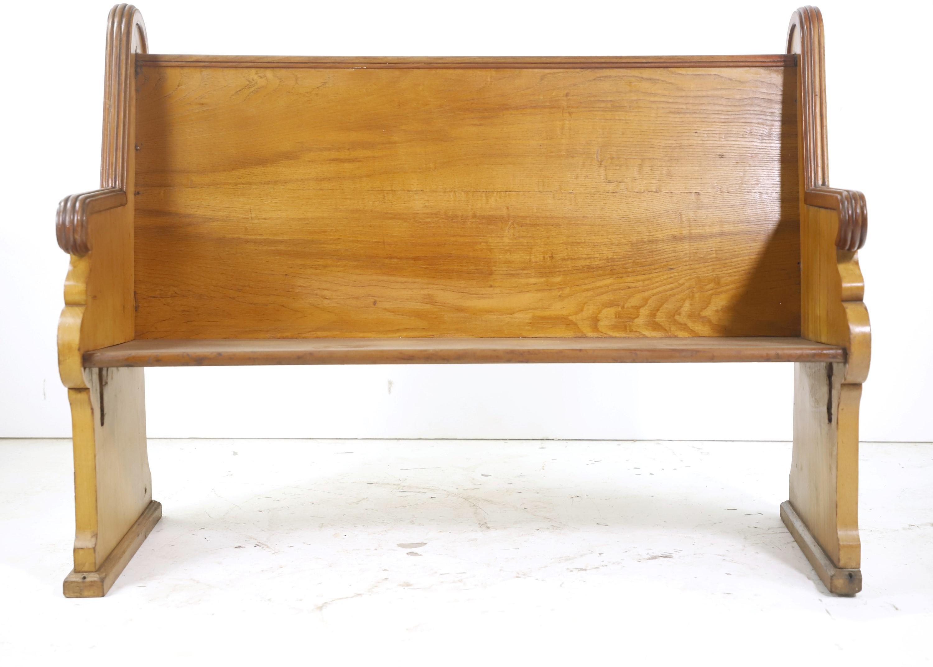 Late 1800s solid oak church pew. Features carved bullseyes on top corners and other carved details. Back has a very slight curve to it. Please note, this item is located in one of our NYC locations.