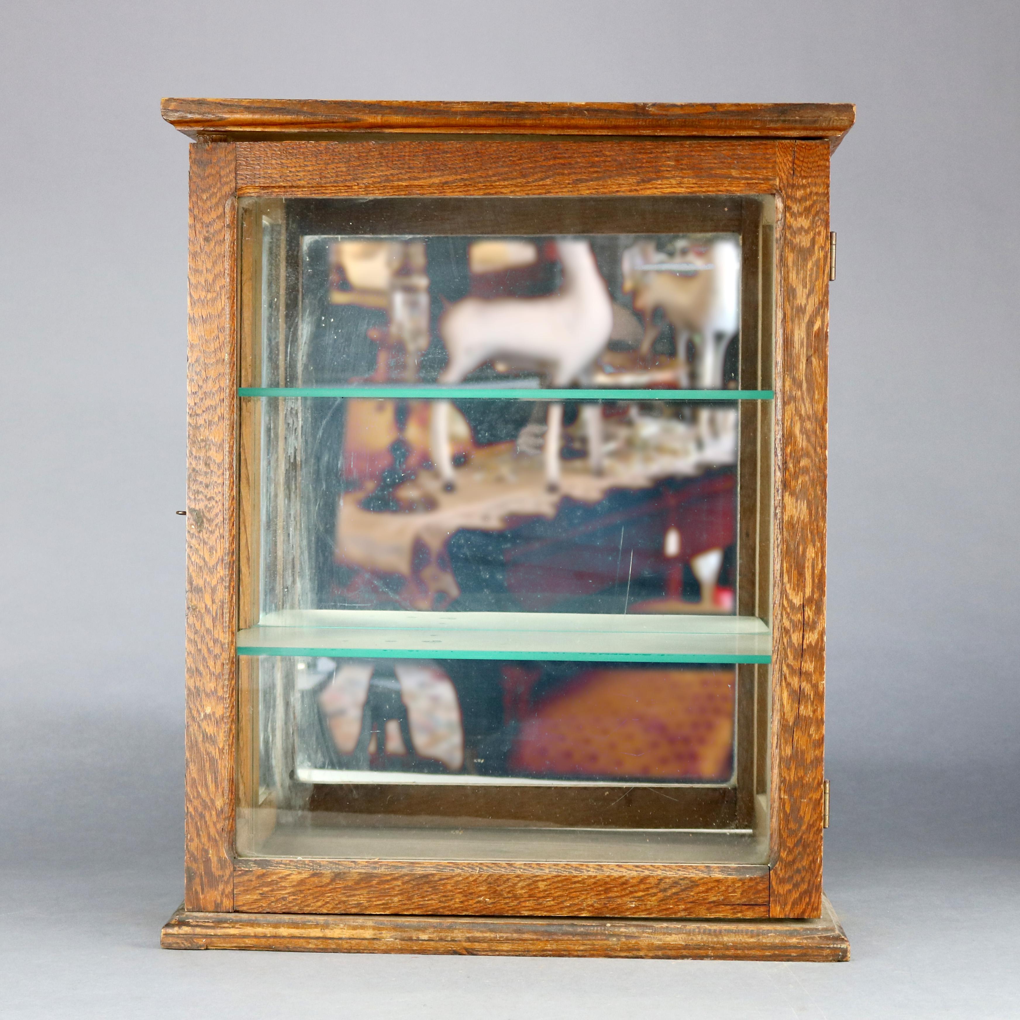 An antique country store display cabinet offers quarter sawn oak construction with glass sides and front door opening to shelved and mirrored interior, circa 1900

Measures: 21.75