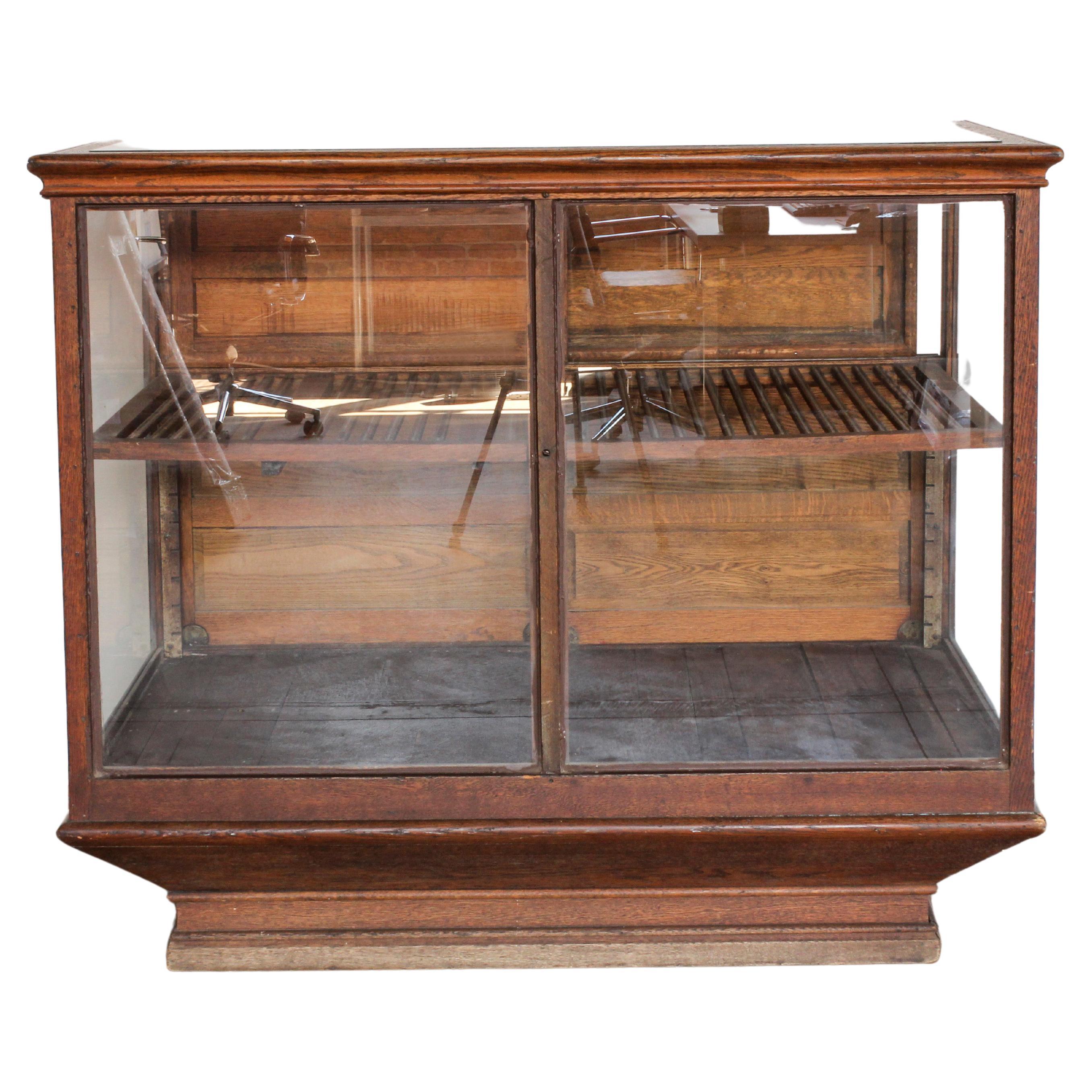 Antique oak curio display case with original glass on three sides. Slatted wood shelf at 16