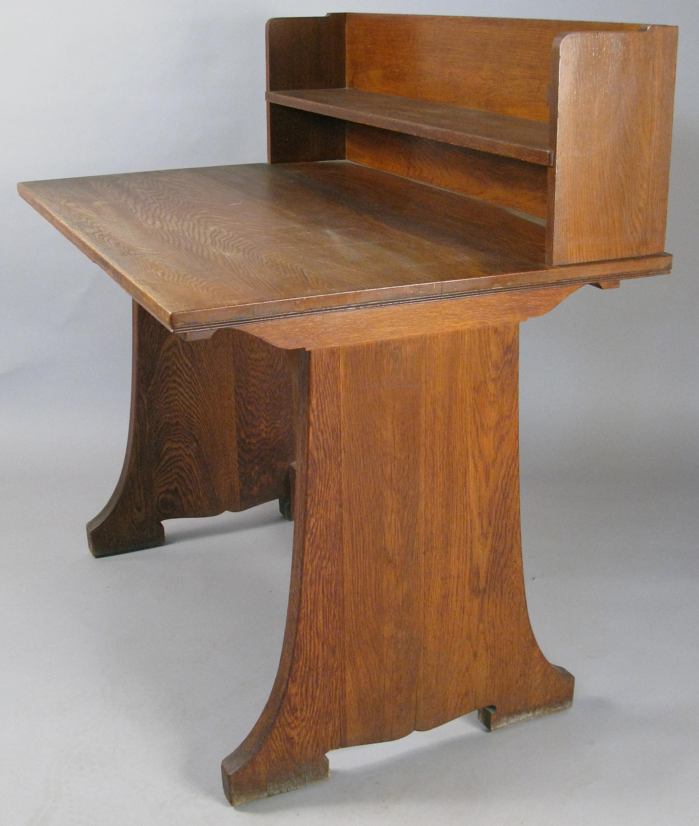 A very handsome antique oak writing desk originally from the Harvard Divinity School. With privacy riser in the back, and a slim shelf. Beautiful design and very well made. In good overall condition.

We have a pair of these desks, priced