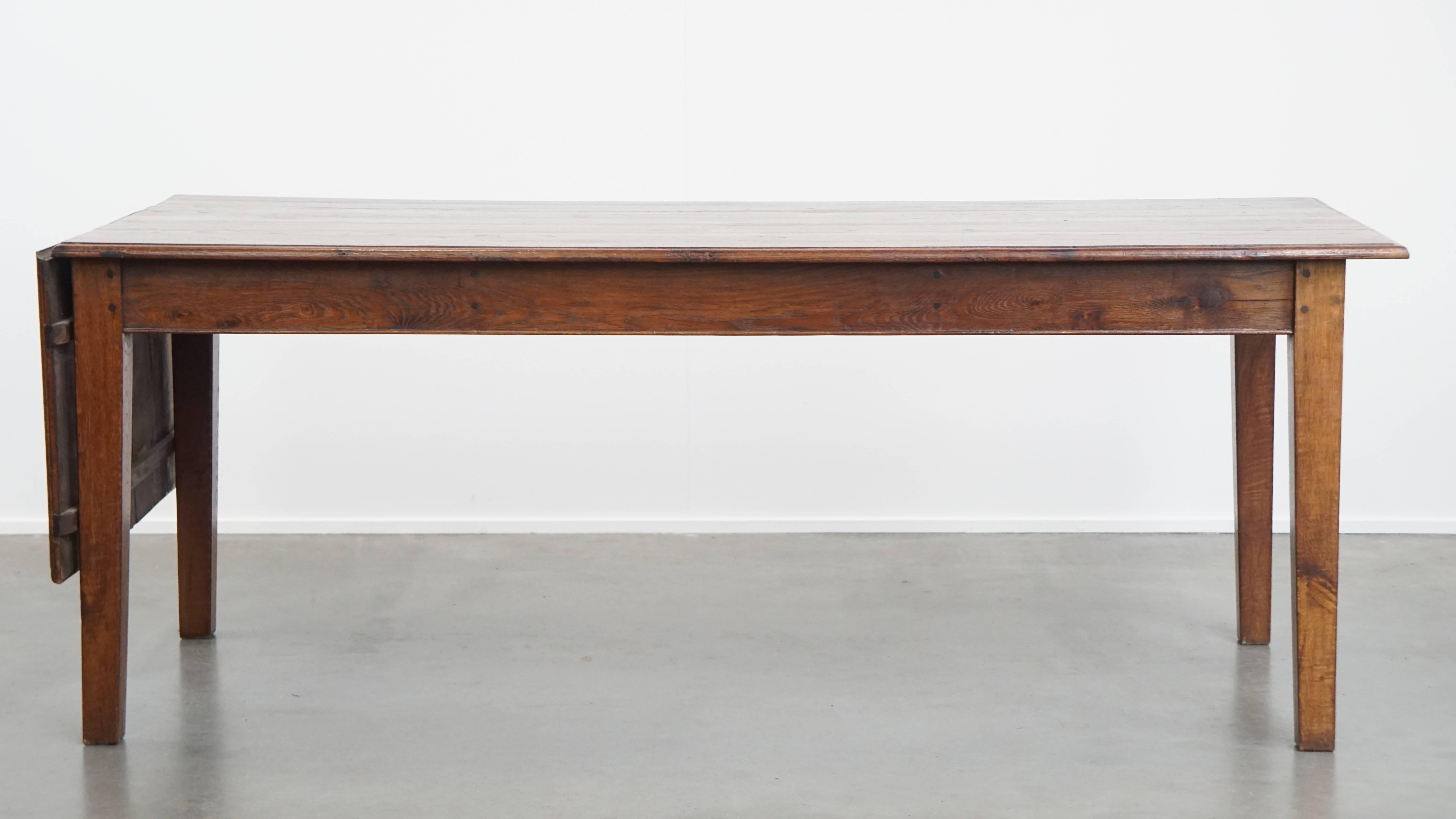 Offered here is this unique antique oak dining table from the early 1900s with a drop-leaf on one side. This beautiful oak table fits seamlessly into almost any interior and, in our opinion, is a true eye-catcher that no home should be