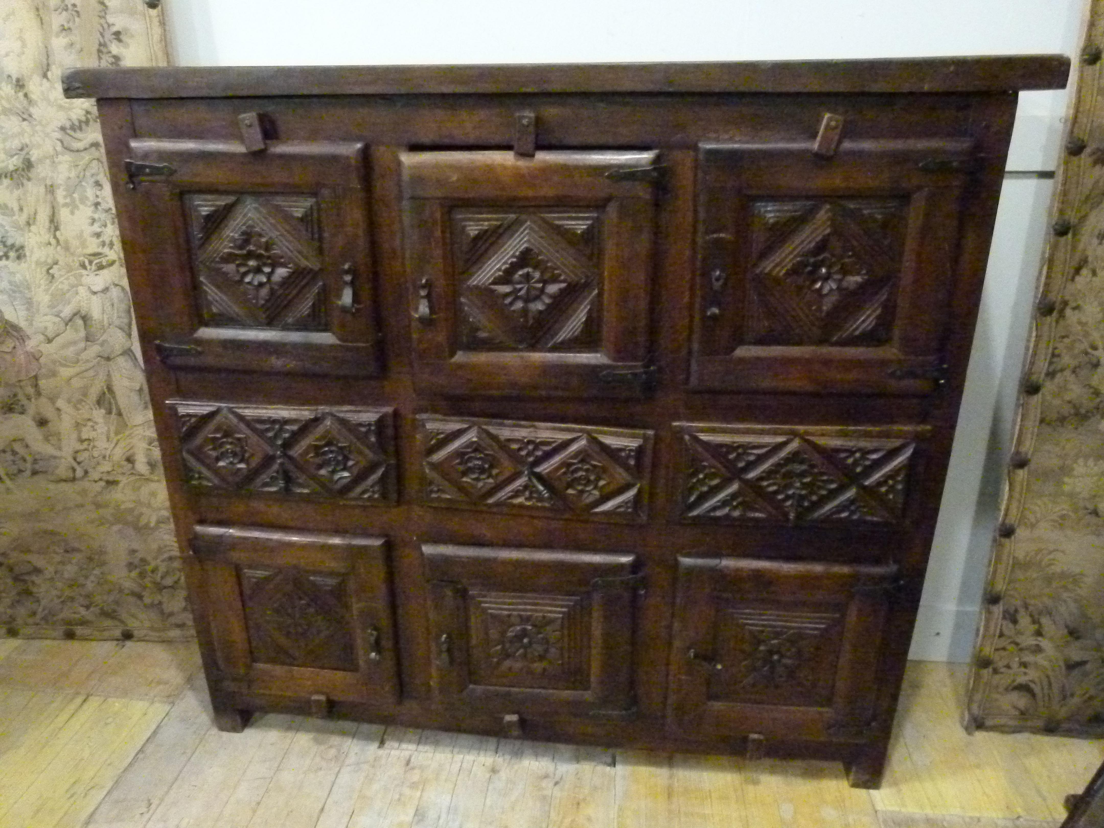 Antique dining cabinet in rustic style. Made of Oak, very stable. Hand carved decorations. The three upper and lower doors open to a common space with a shelf. In the middle three drawers. 

