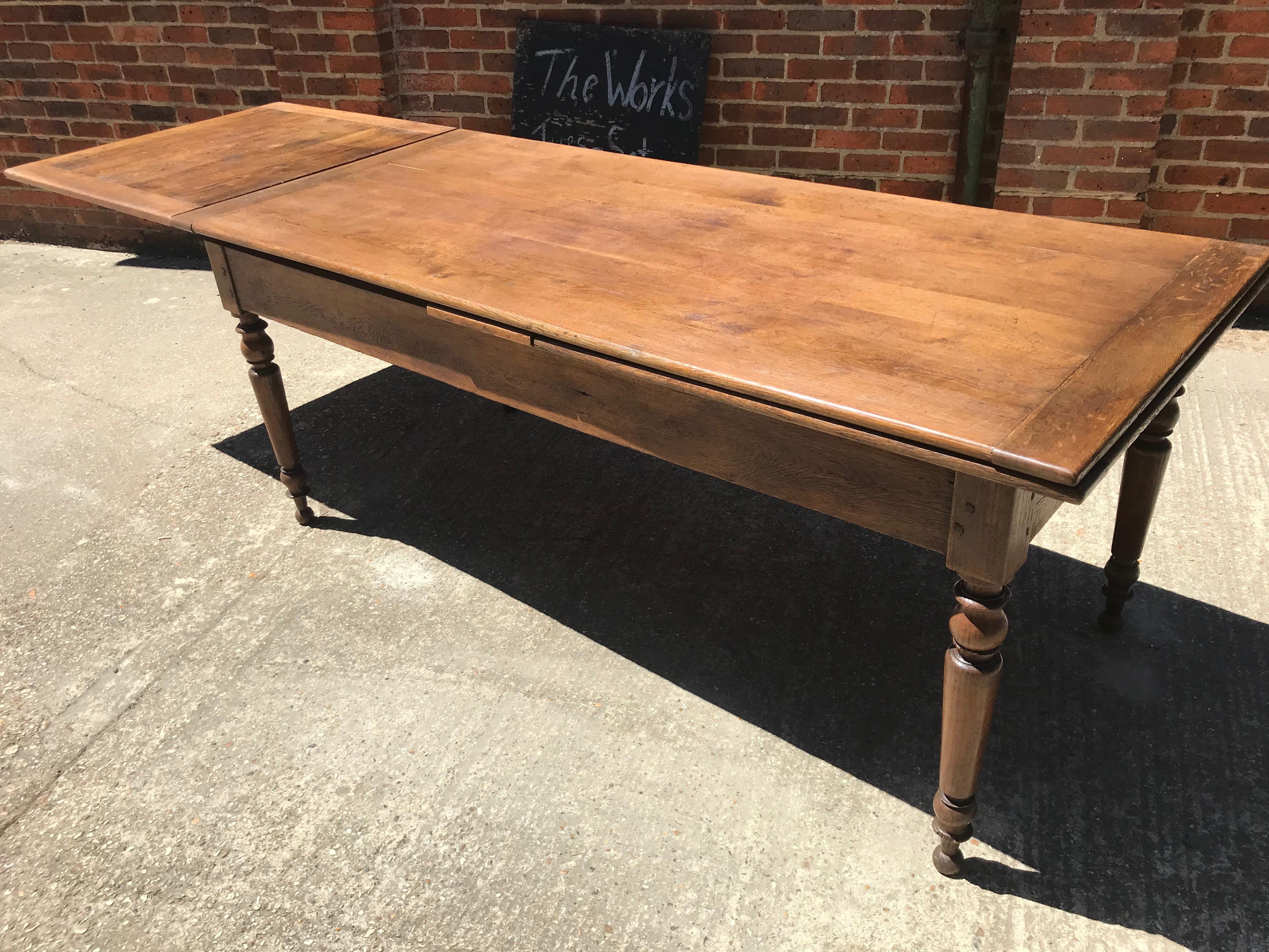Antique oak double extending table with round legs and gorgeous patina. This table can extend on both sides and would seat up to 12 people comfortably. You can use this table as a eight-seat with both extensions tucked in, or with one extending side