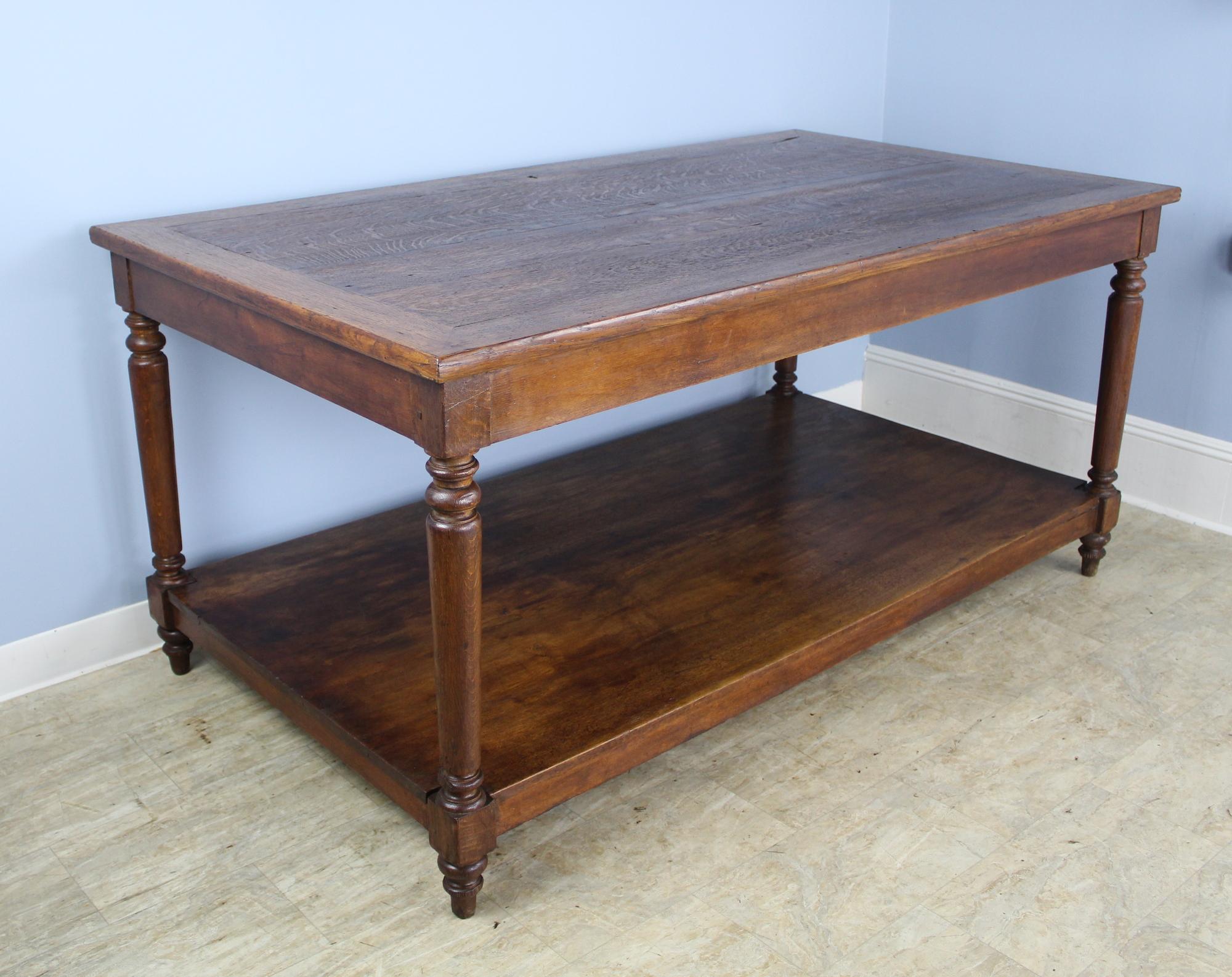 A highly versatile work station or table in dark oak. At 33 inches high, this piece work nicely in the kitchen as a stylish work surface. Apron height is 28 inches. Turned legs and lower shelf for books (or feet) completes the look.