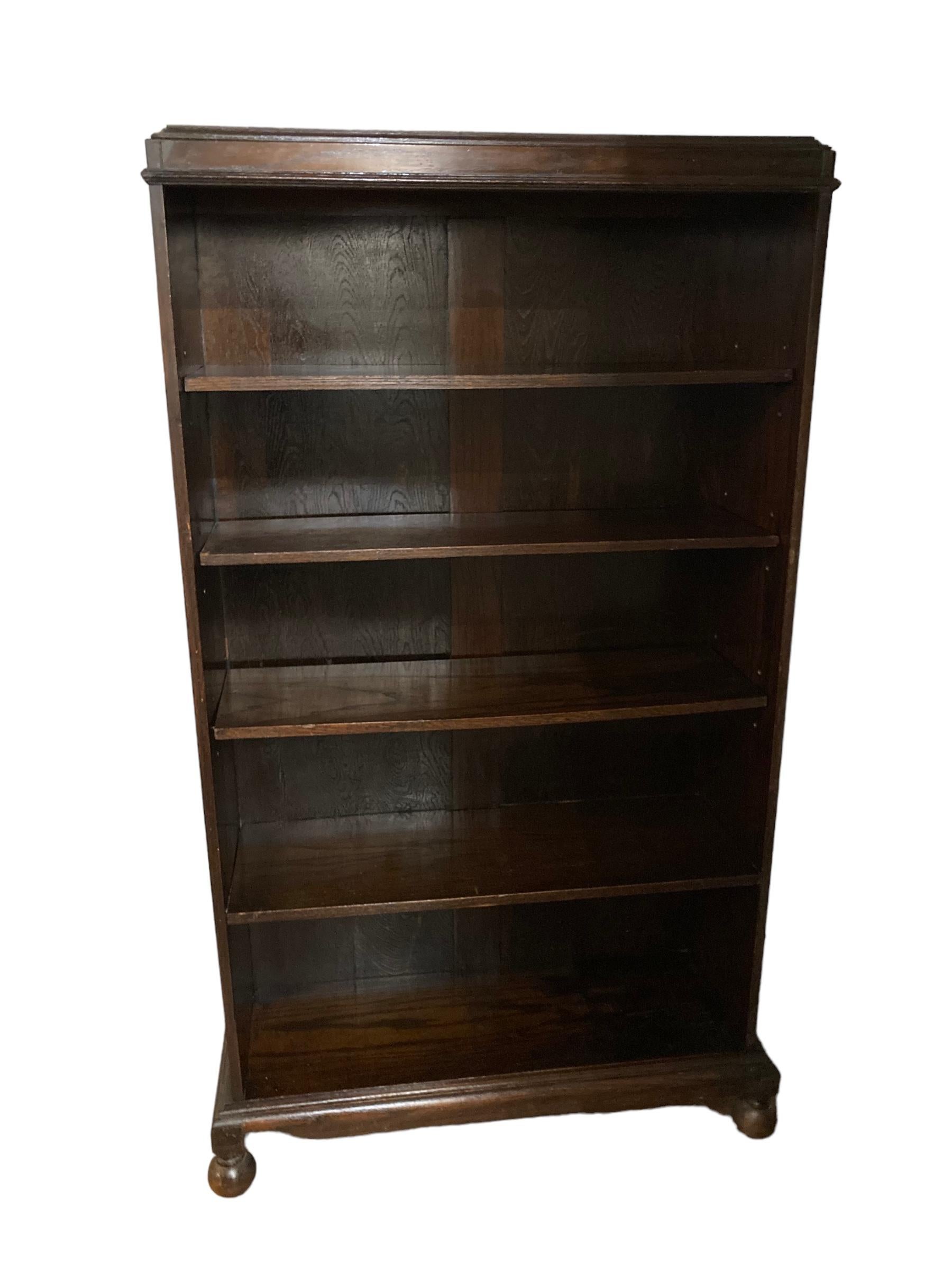 Early 1900's Victorian Dark Oak Bookcase, 4 shelves, 5 book compartments, bun feet to front. Fixed bottom shelf with 3 height adjustable shelves.

H: 140 cm

W: 78 cm

D: 27 cm

Bottom shelf height, fixed : 27cm

Further adjustable shelves 24cm or