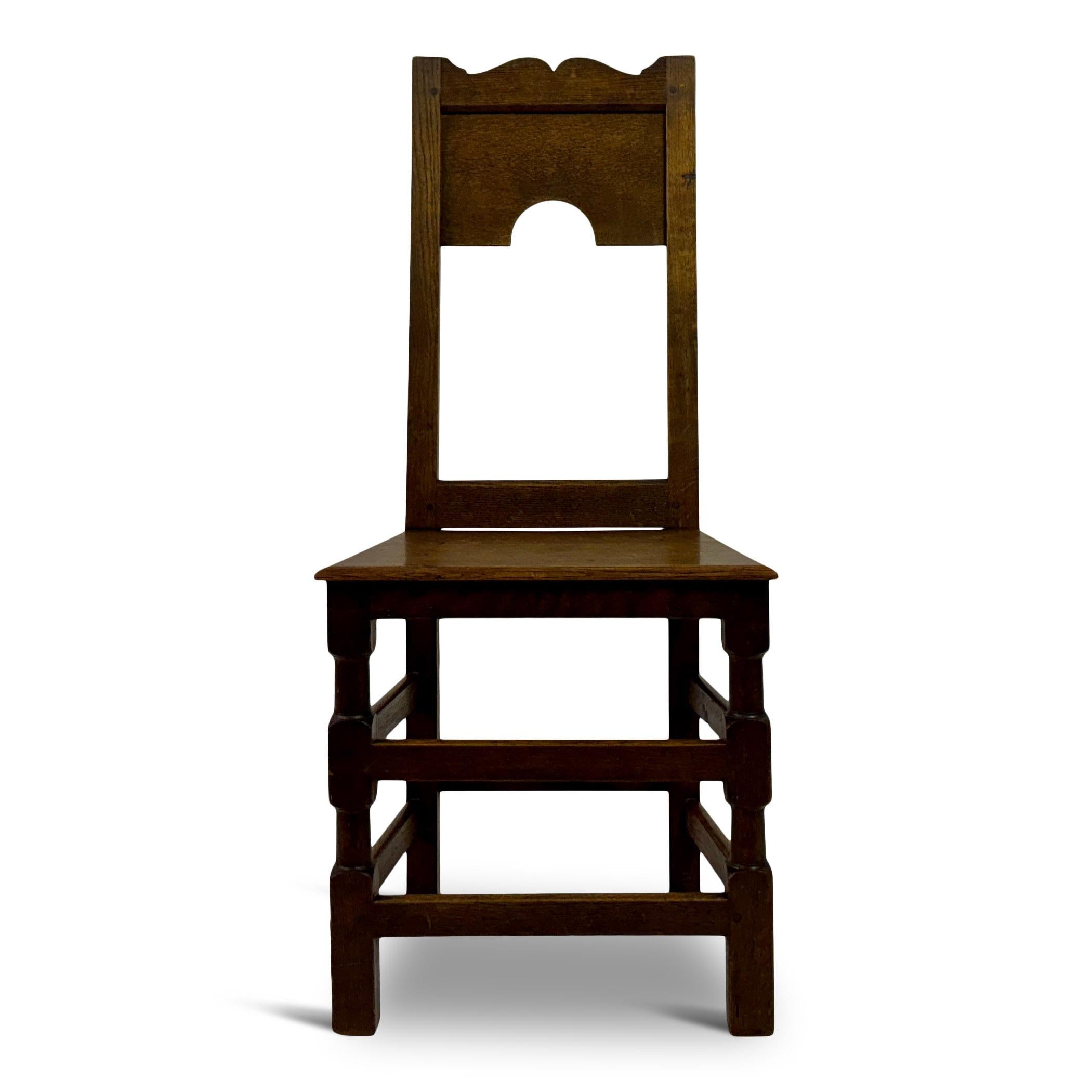 Side chair

Oak

Simple geometric shaped legs

Seat height 46cm

An oak chair with a simple yet distinctive design. The chair features a straight, rectangular backrest with a solid wooden panel that has a cut-out arch in the lower centre, adding a