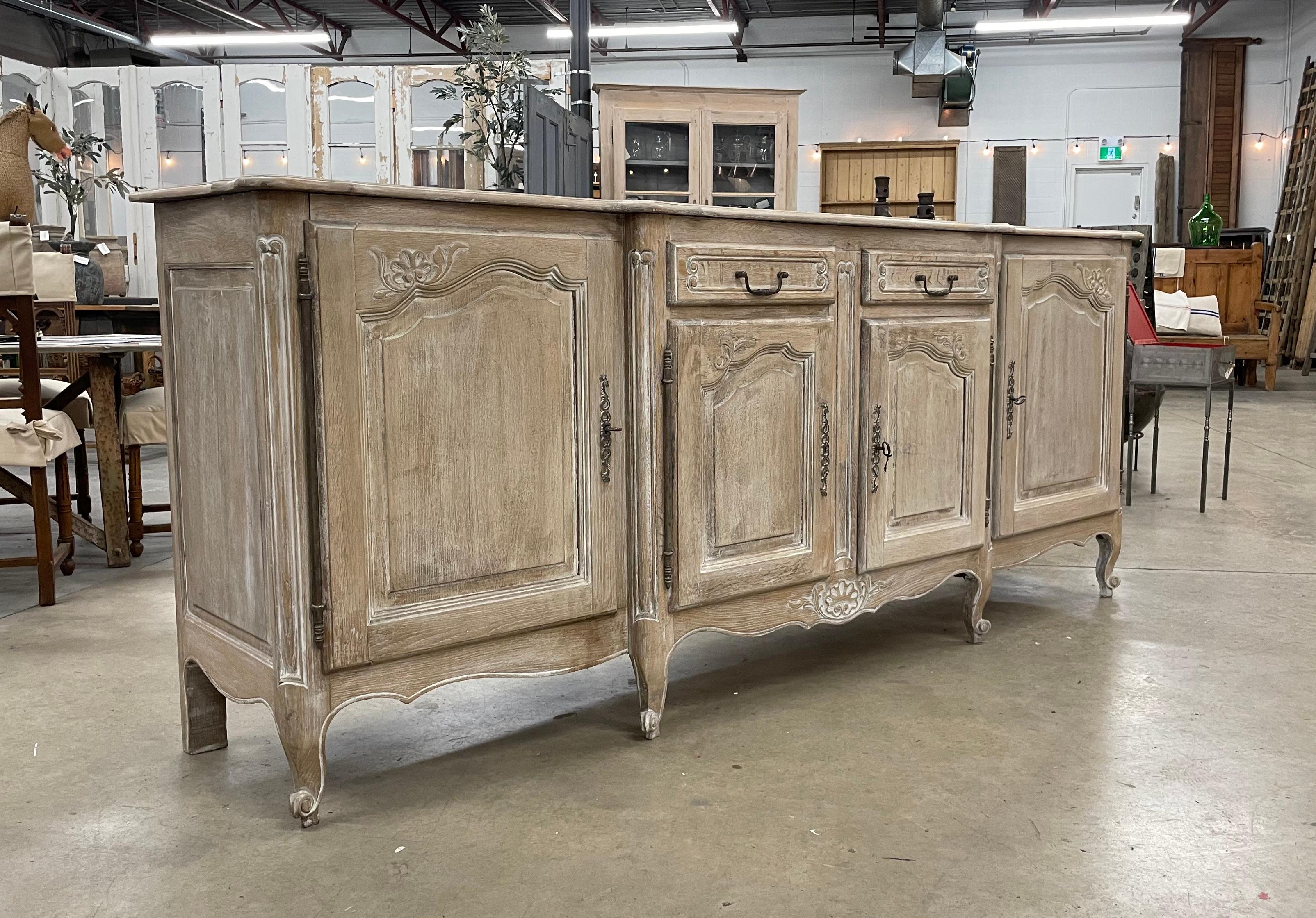 Substantial antique bleached and limed oak breakfront Louis XVI style enfilade with 4 doors and 2 drawers. Exceptional quality with parquetry top, beautiful hand wrought iron escutcheons, snail feet, and scalloped bottom apron.