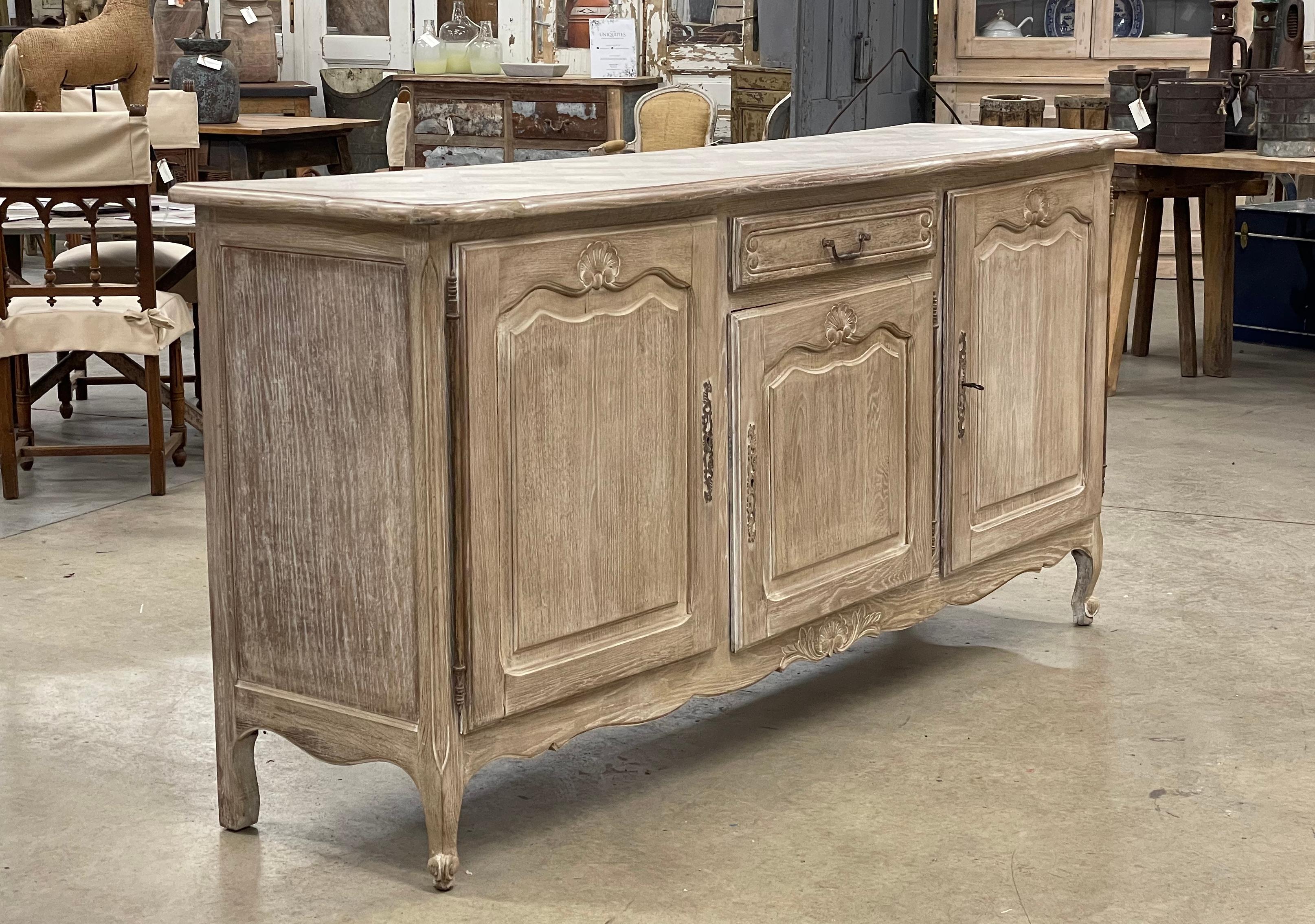 Substantial antique bleached and limed oak breakfront Louis XVI style enfilade with 3 raised panel doors and 1 drawer. Exceptional quality with parquetry top, beautiful hand wrought iron escutcheons, snail feet, and scalloped bottom apron.