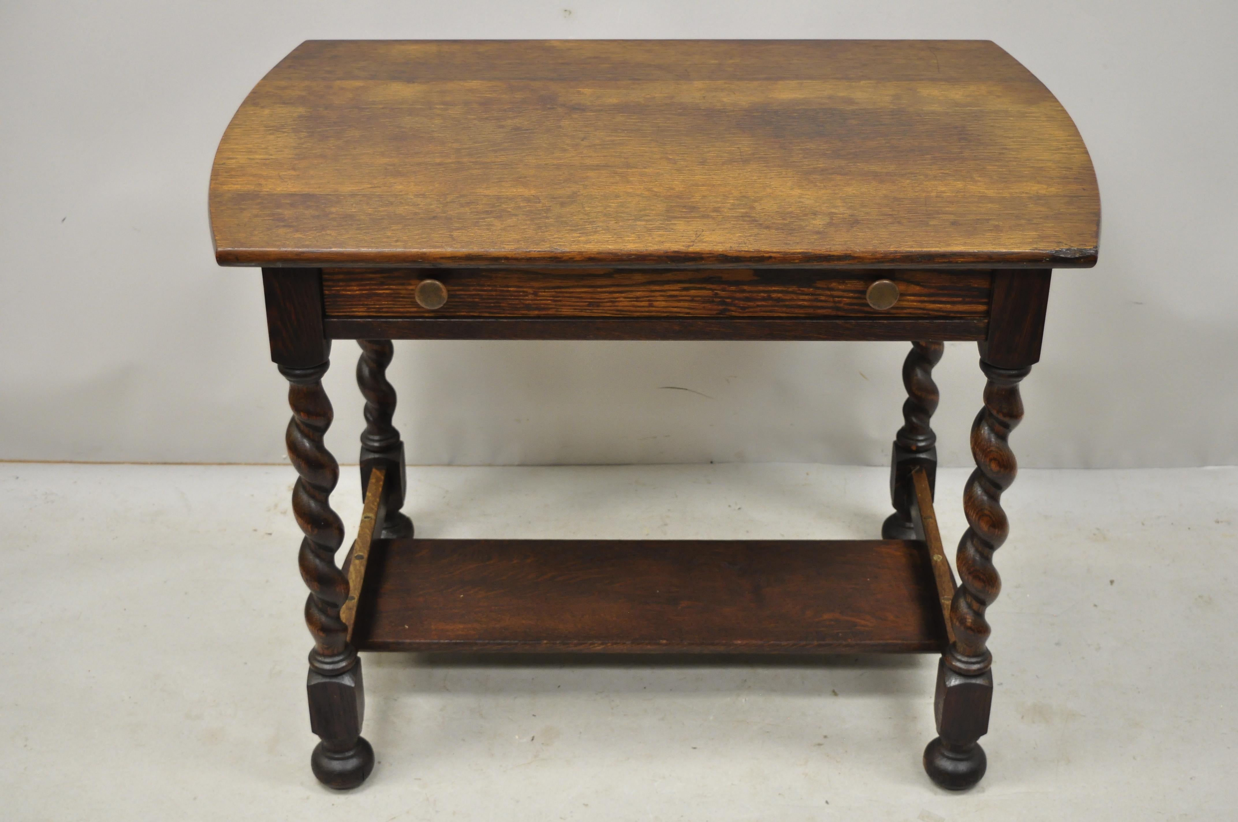 Antique oak English Jacobean spiral barley twist table desk with one drawer. Item features spiral carved barley twist legs, lower shelf, solid wood construction, beautiful wood grain, original label remnants, 1 drawer, very nice antique item, circa
