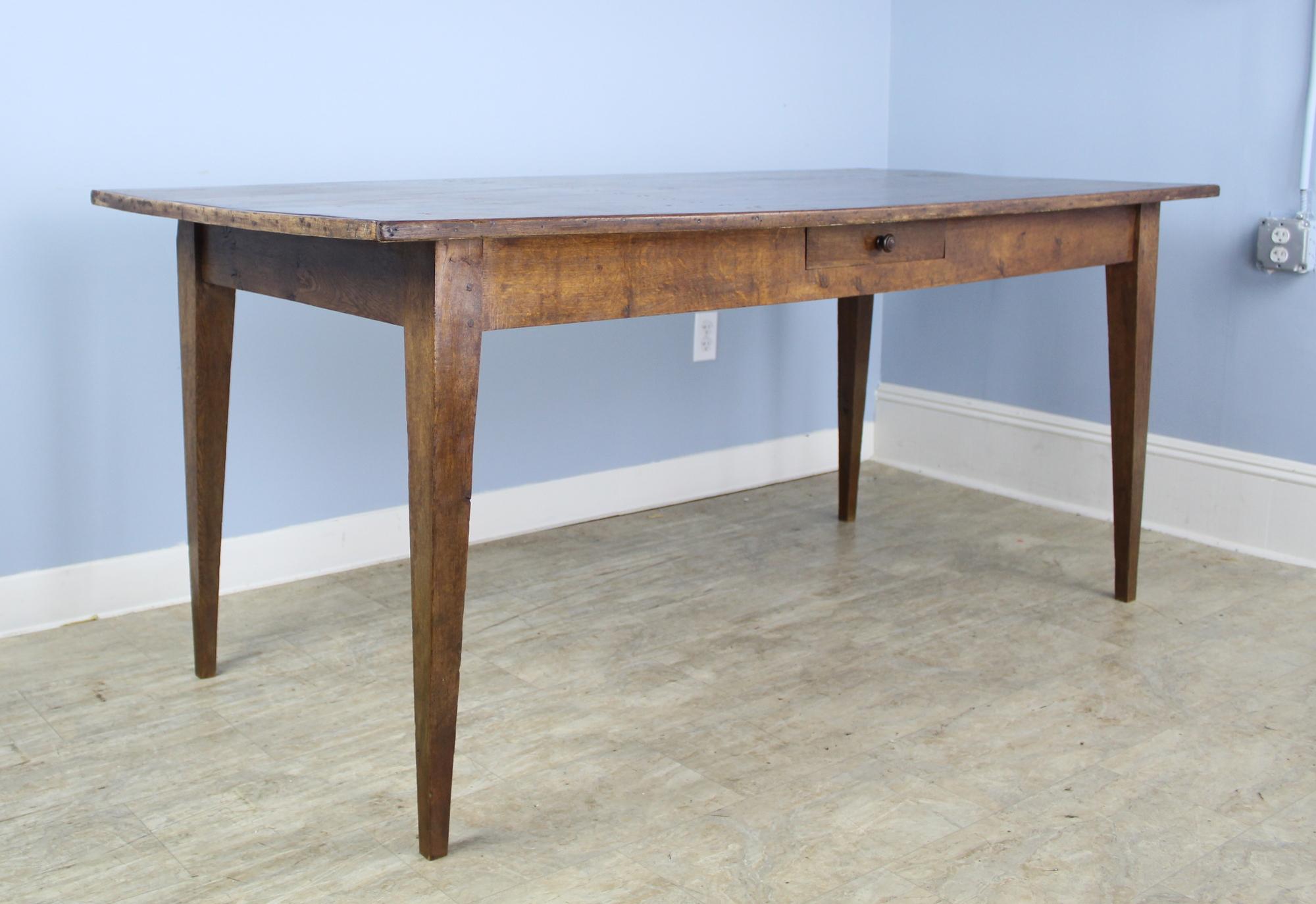A charming French oak farm table with lots of visual impact. Notably a sturdy and attractive decorative edge and a carved single center drawer. 25