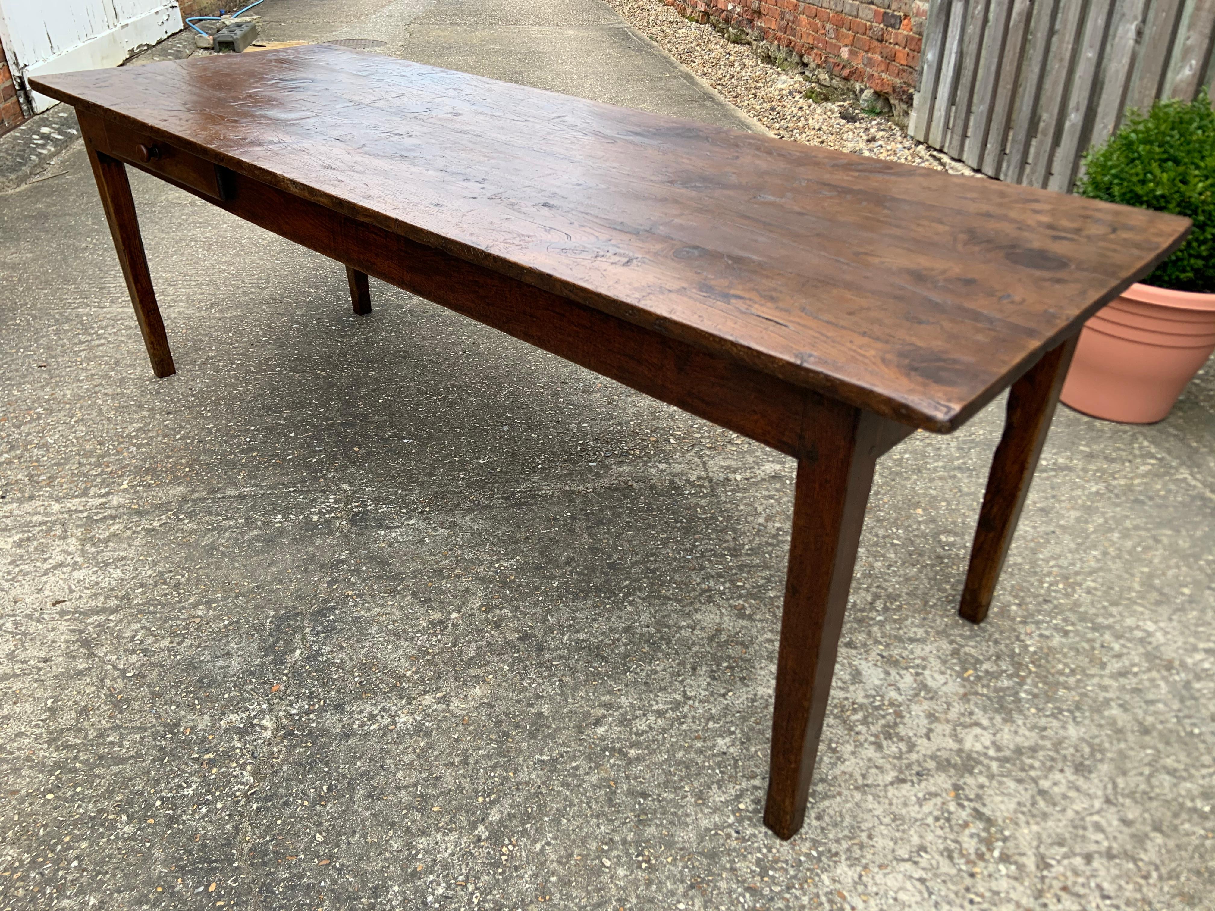 Antique oak farmhouse table with one drawer. The table sits on four tapered legs with a beautiful patinated top. 

 