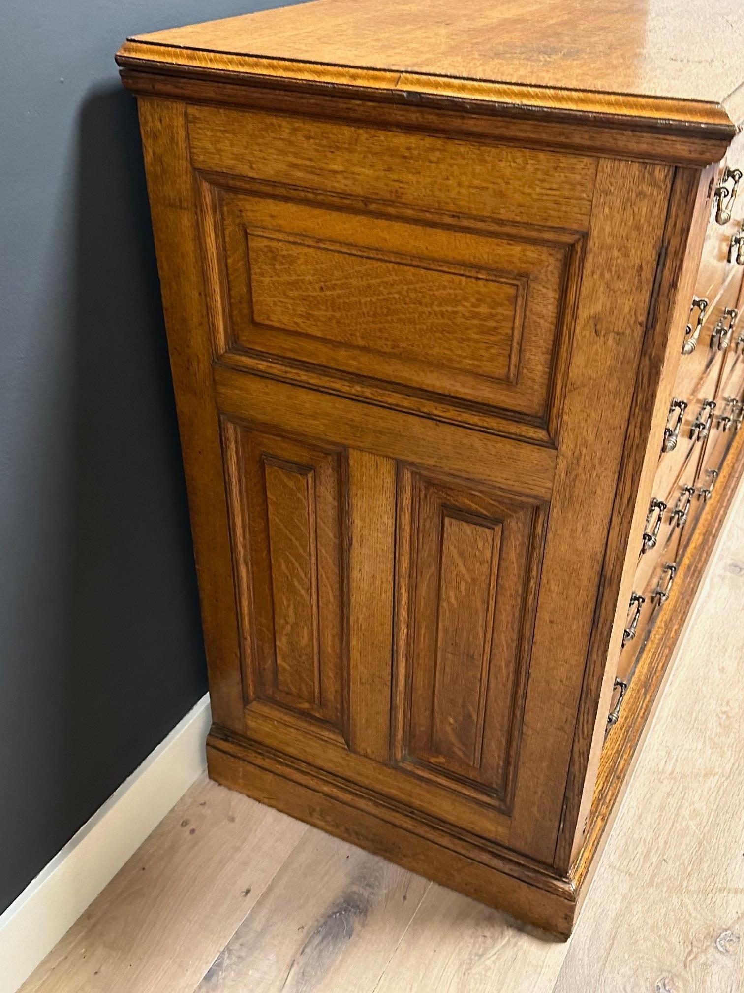 Magnifique classeur en chêne ancien avec 12 tiroirs qui augmentent en hauteur. Il est entièrement d'origine et en parfait état. Les montants extérieurs servent de serrures, à l'instar d'une commode Wellington. Aucune clé n'est incluse.
L'armoire a