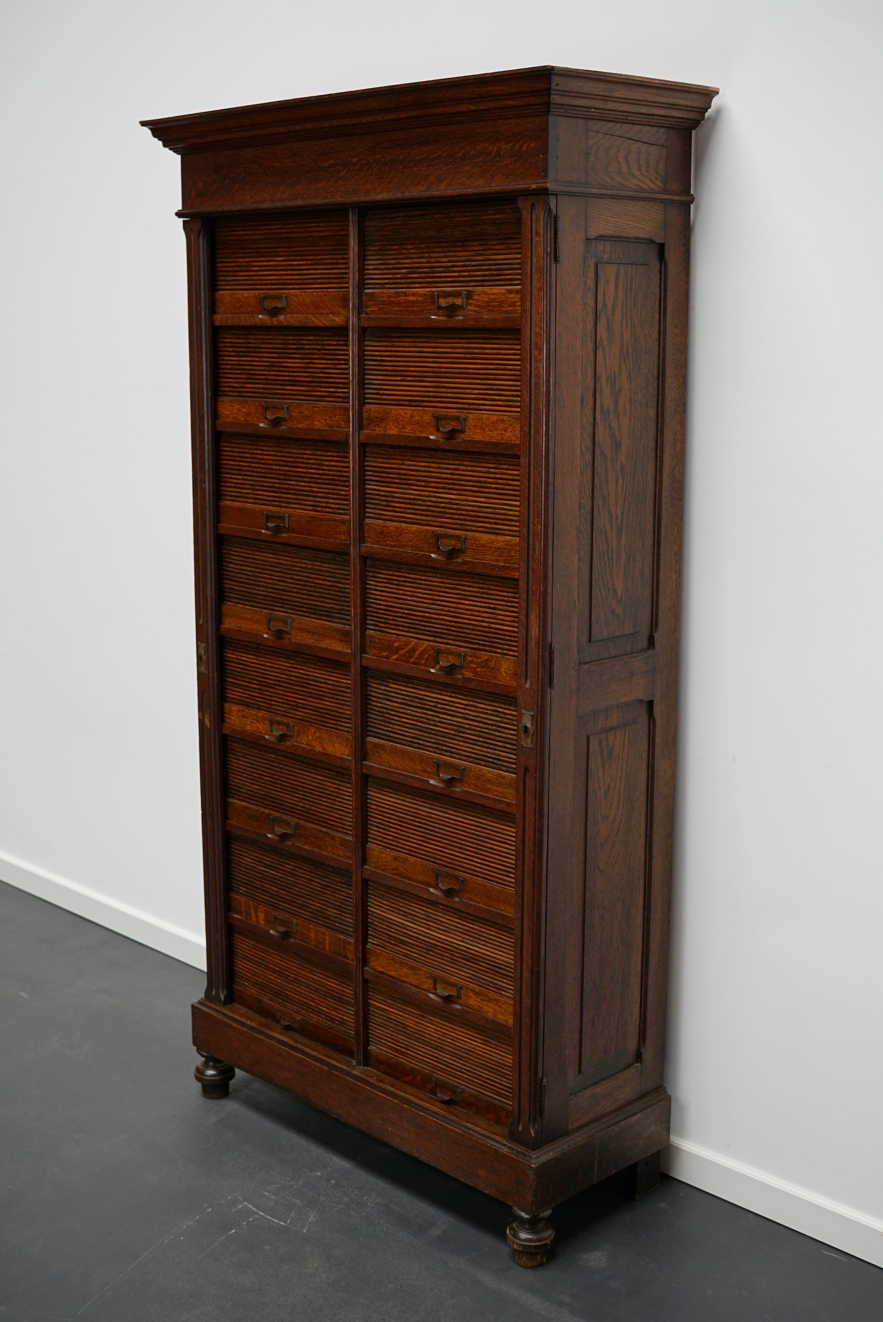 Very nice oak filing cabinet from the early 20th century with 16 tambour doors. The interior dimensions of the compartments are A4 paper size.